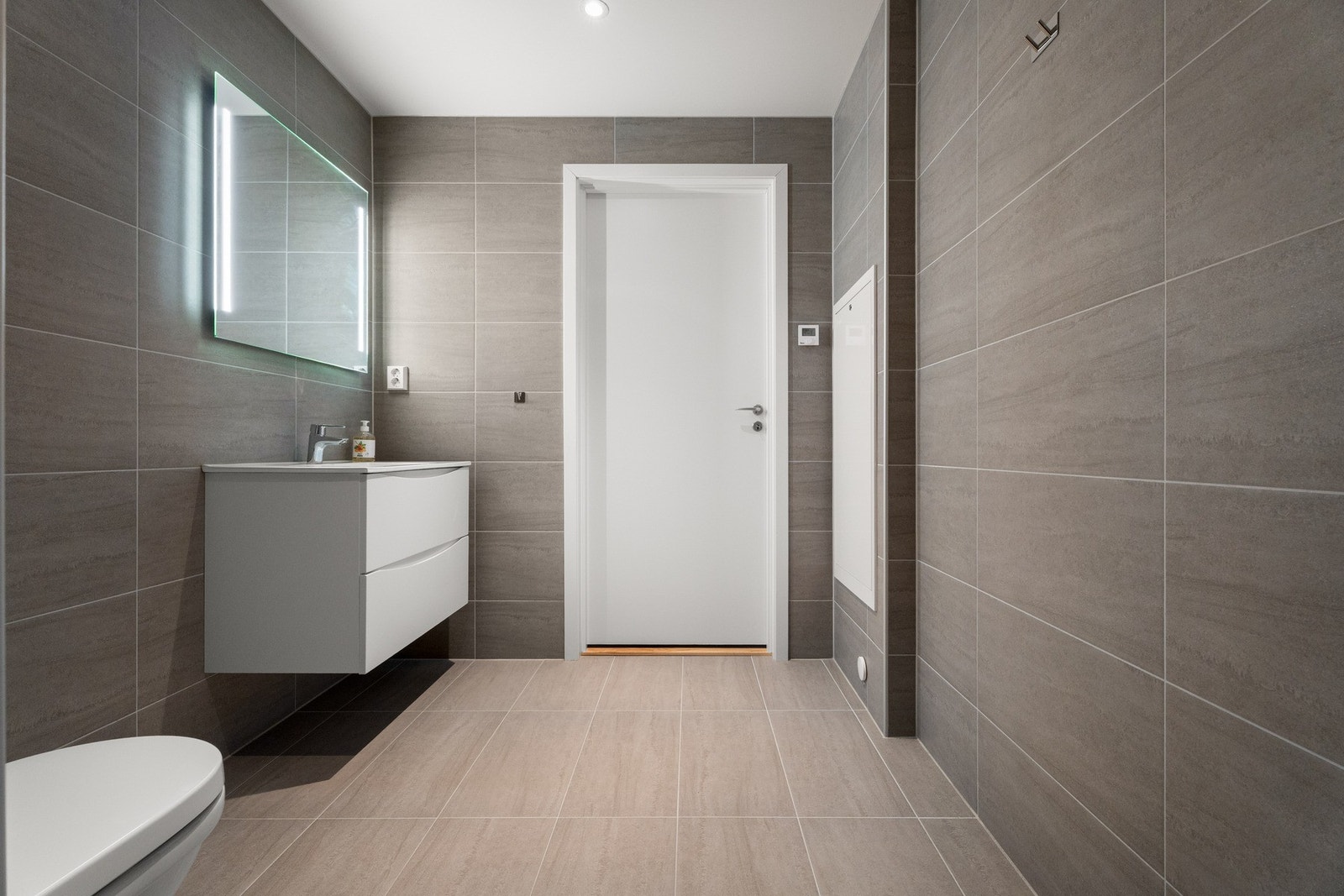 Vegghengt toalett og dusj på vegg, samt opplegg og plass til vaskemaskin Galleribilde