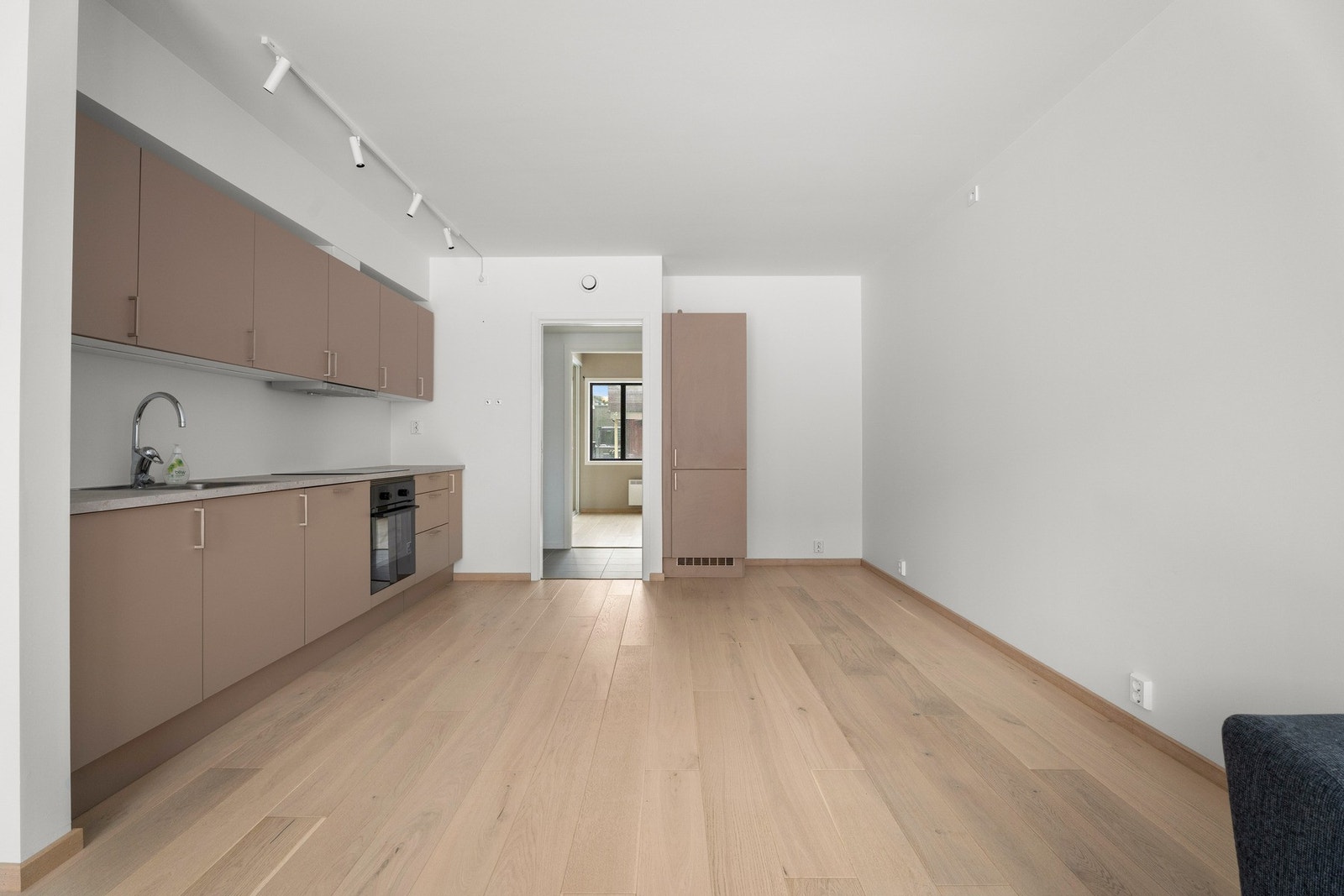 Delikat kjøkken med innredning med slette fronter, laminat benkeplate og integrert kjøle/fryseskap, oppvaskmaskin, platetopp og stekeovn Galleribilde