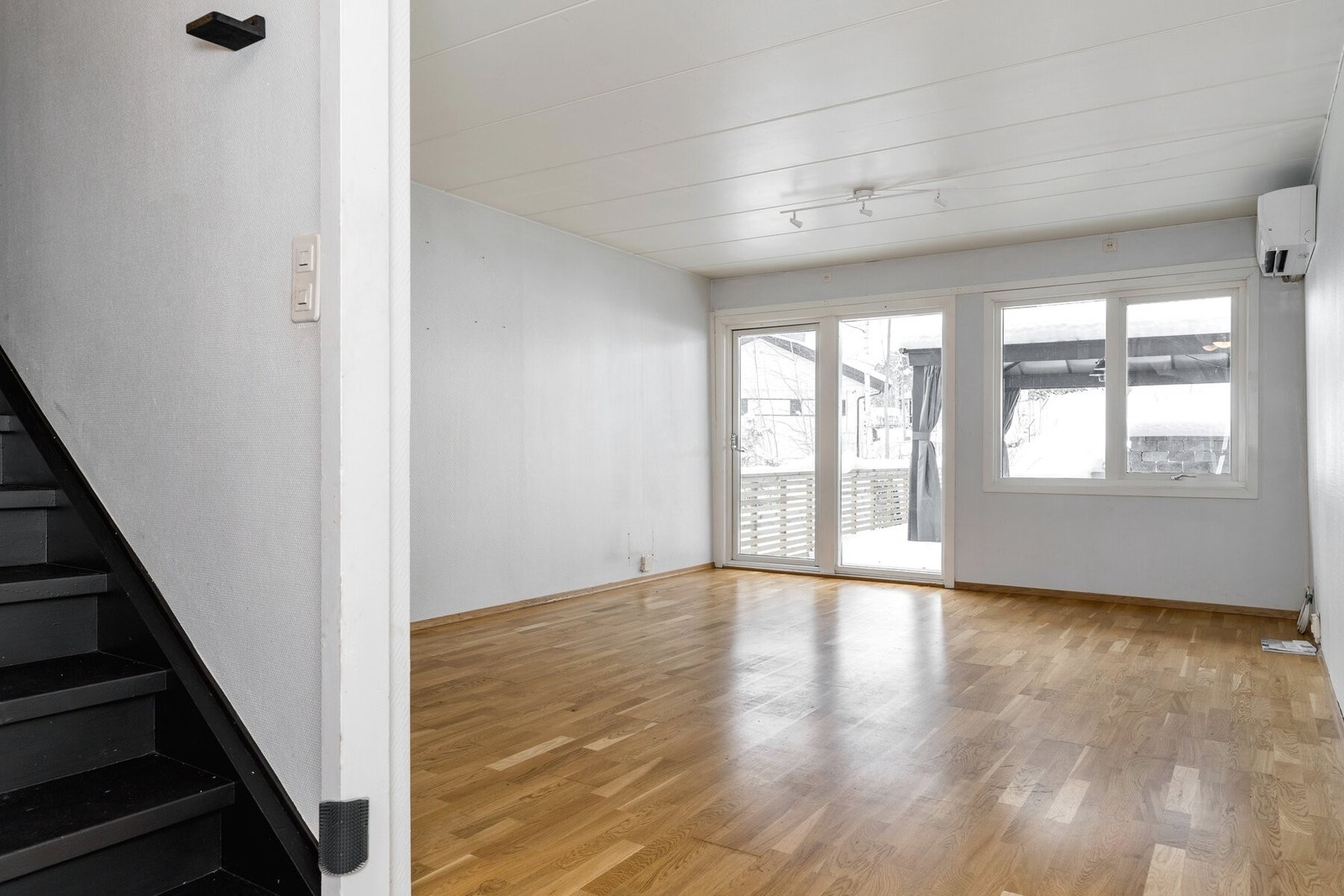 Stue med store vindusflater som slipper inn godt med lys. Verandadør og vinduer ble byttet i 2019/2020. Galleribilde