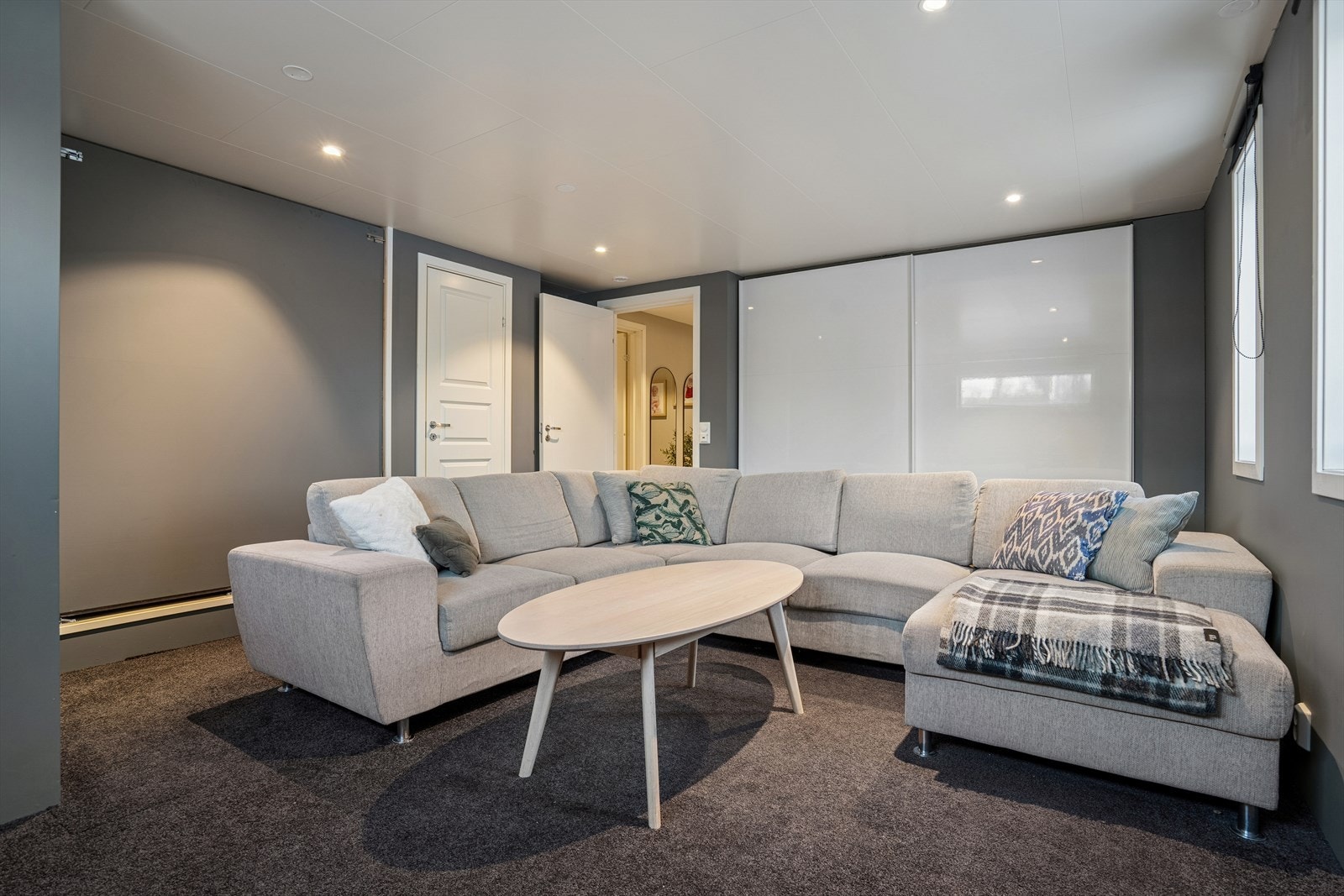 Kjellerstuen er utført i gråtoner som gir rommet et moderne og dempet uttrykk Galleribilde