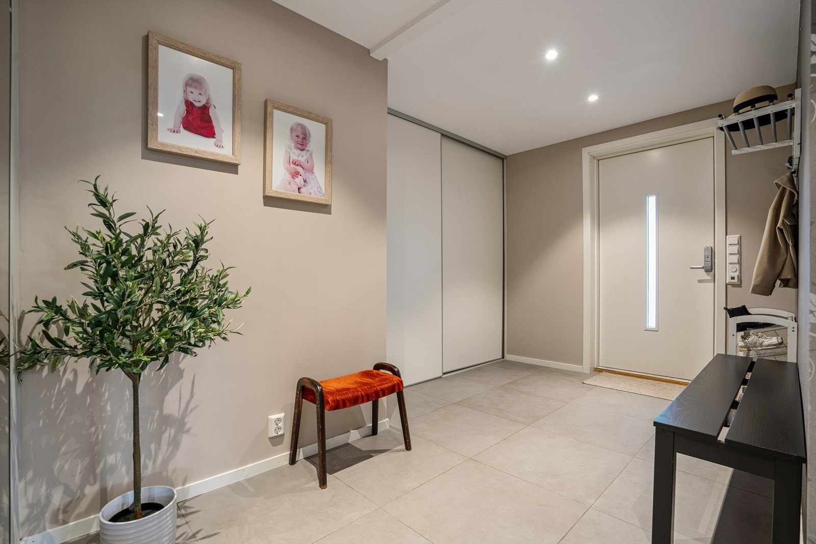 Du ønskes velkommen inn i en entré lys og innbydende med flislagt gulv (elektriske varmekabler) og slette veggflater malt i en moderne farge - Ytterdøren har kodelås som gir nøkkelfri hverdag Galleribilde