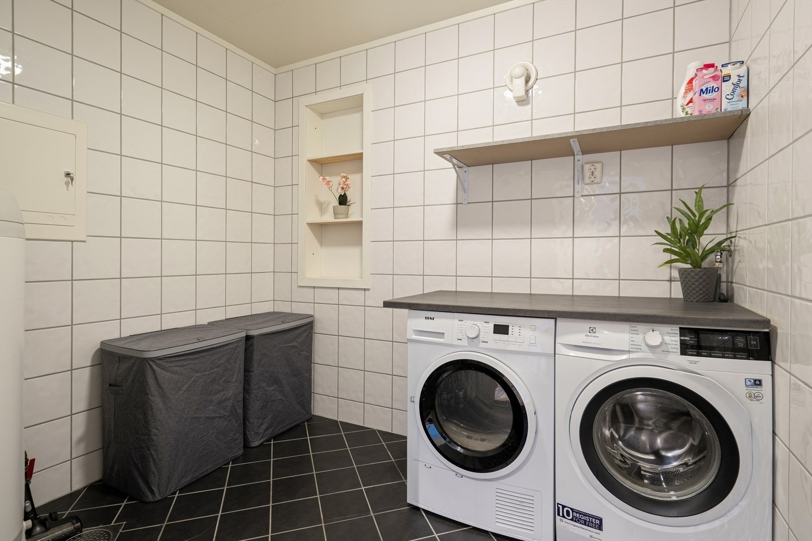 Vaskerommet er praktisk og funksjonelt med flislagt gulv (elektriske varmekabler) og flislagte vegger - Her er det benkeplate med god plass til både vaskemaskin og tørketrommel under Galleribilde