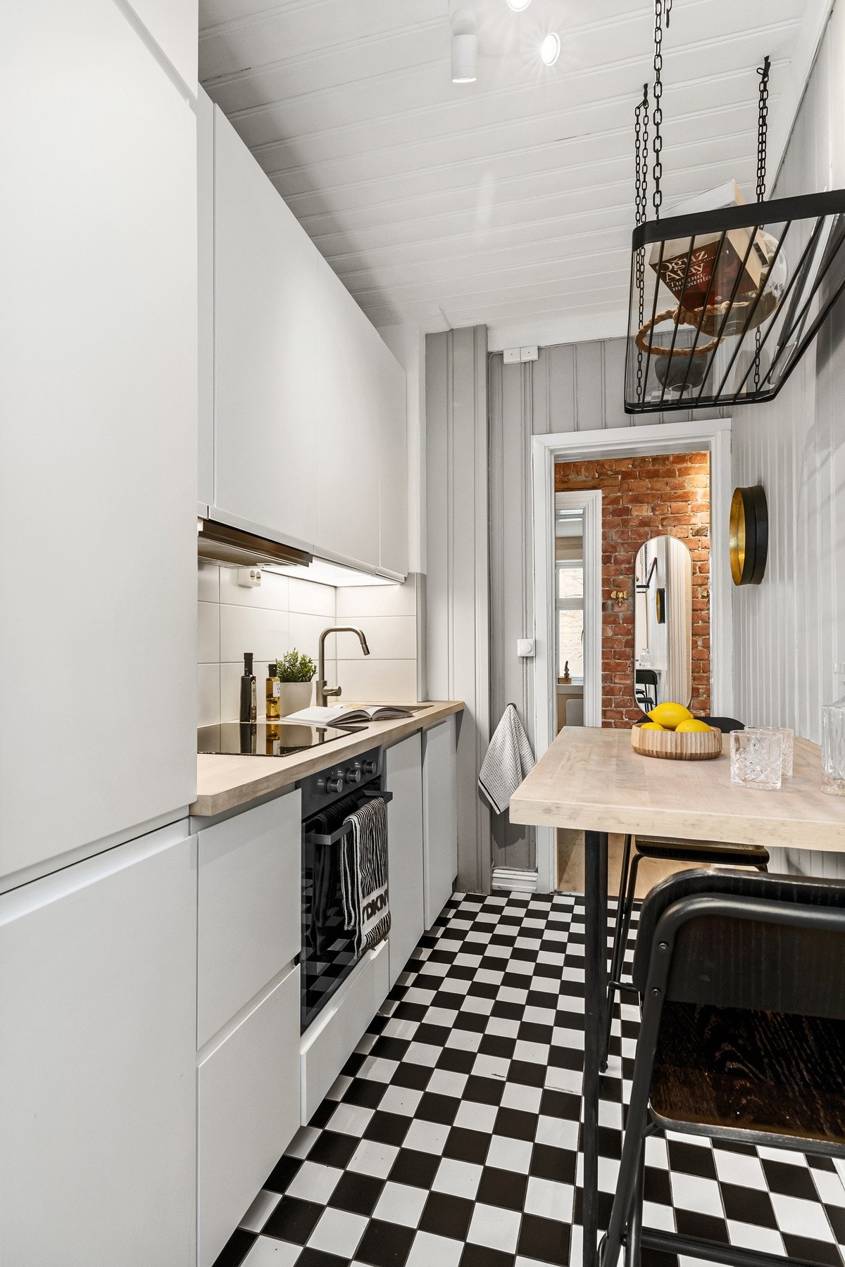 Sjarmerende sjakkfliser kombinert med moderne materialvalg og integrerte hvitevarer. Galleribilde