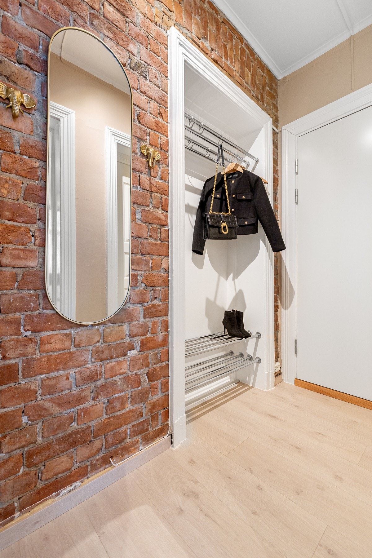Supersjarmerende teglstensvegg i entré. Tidligere døråpning er tettet igjen og benyttes i dag som en praktisk nisje for oppheng. Galleribilde