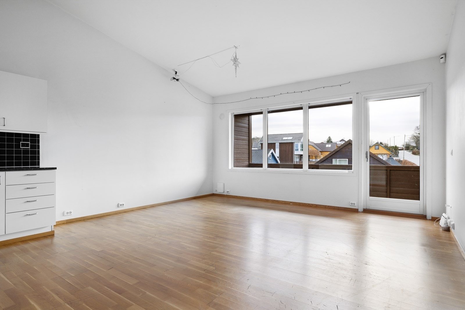 Lys stue/kjøkken med store vinduer og utgang til sørvendt terrasse Galleribilde