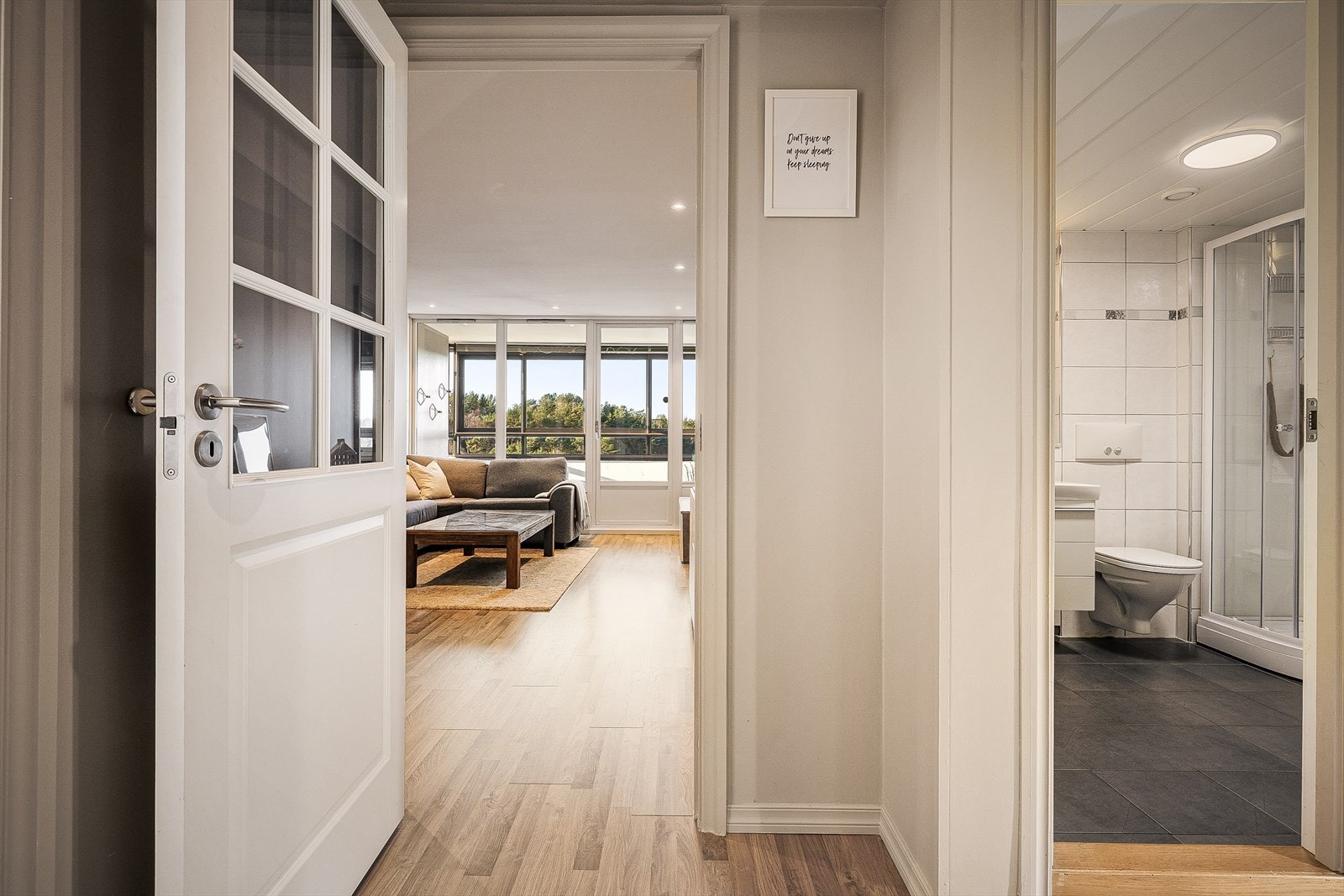 Fra entréen ledes du videre inn mot den romslige stuen, med badet praktisk plassert rett innenfor. Galleribilde