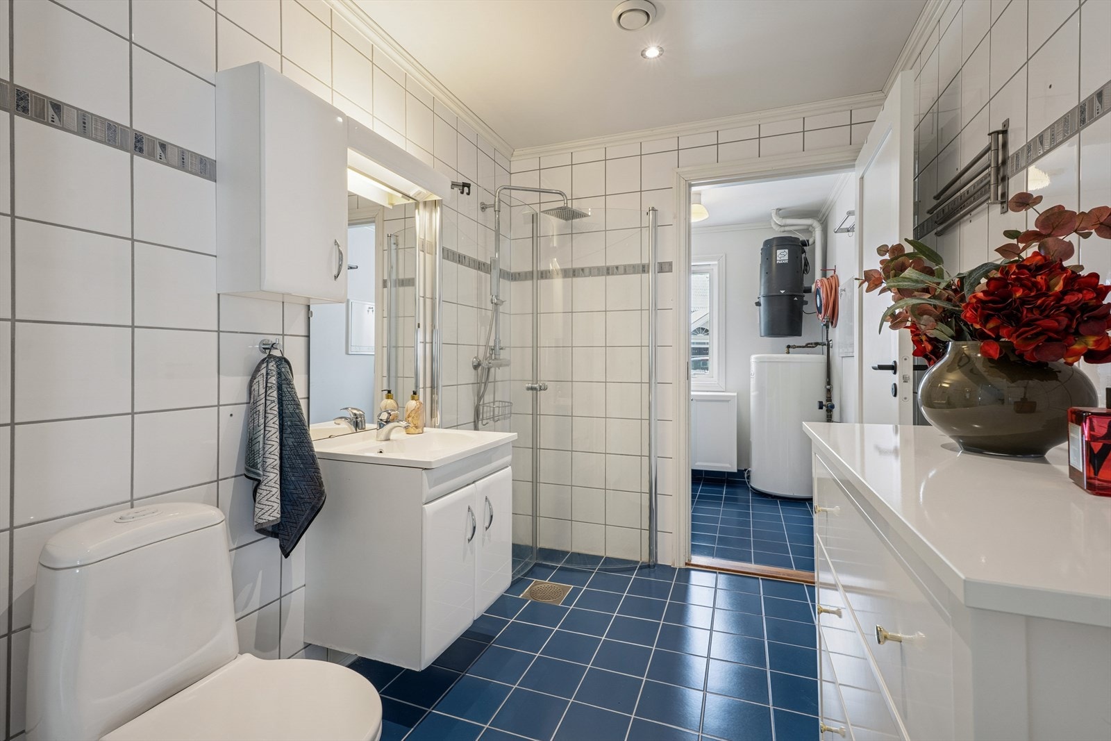 Baderom fra byggeår i 1.etasje. Helfliset med varmekabler i gulvet. Galleribilde