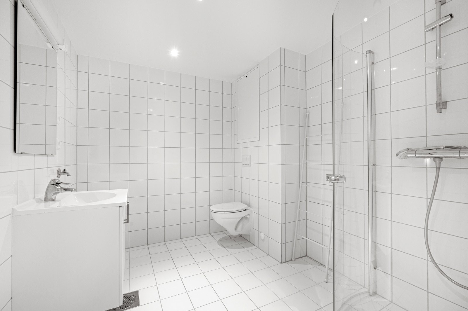 Flislagt bad med vegghopphengt kloset og dusj Galleribilde