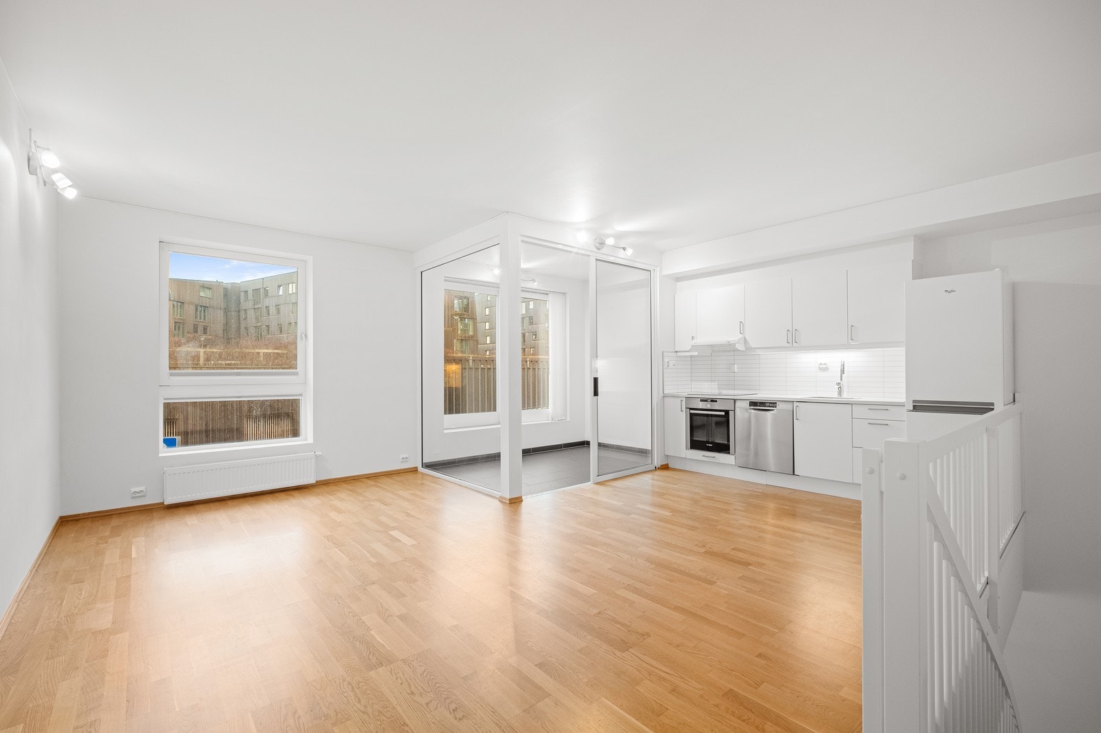 Stue med åpen kjøkken løsning og innglasset balkong. Galleribilde