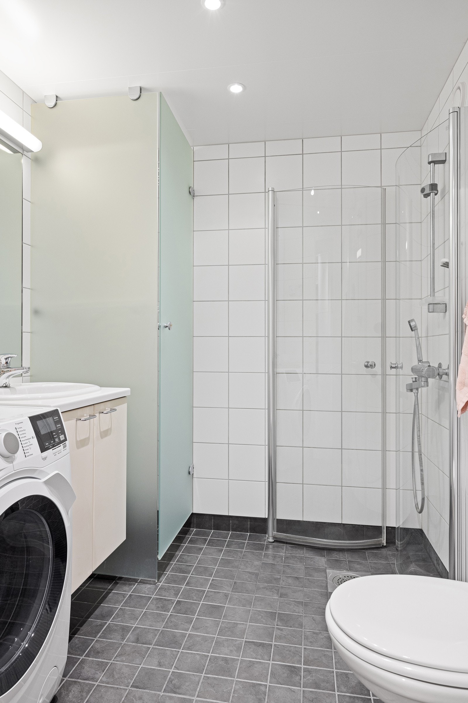 - Vegghengt toalett, dusjnisje med innfellbare dusjvegger, servant med skap, tørkeskap og speil med lys - Galleribilde