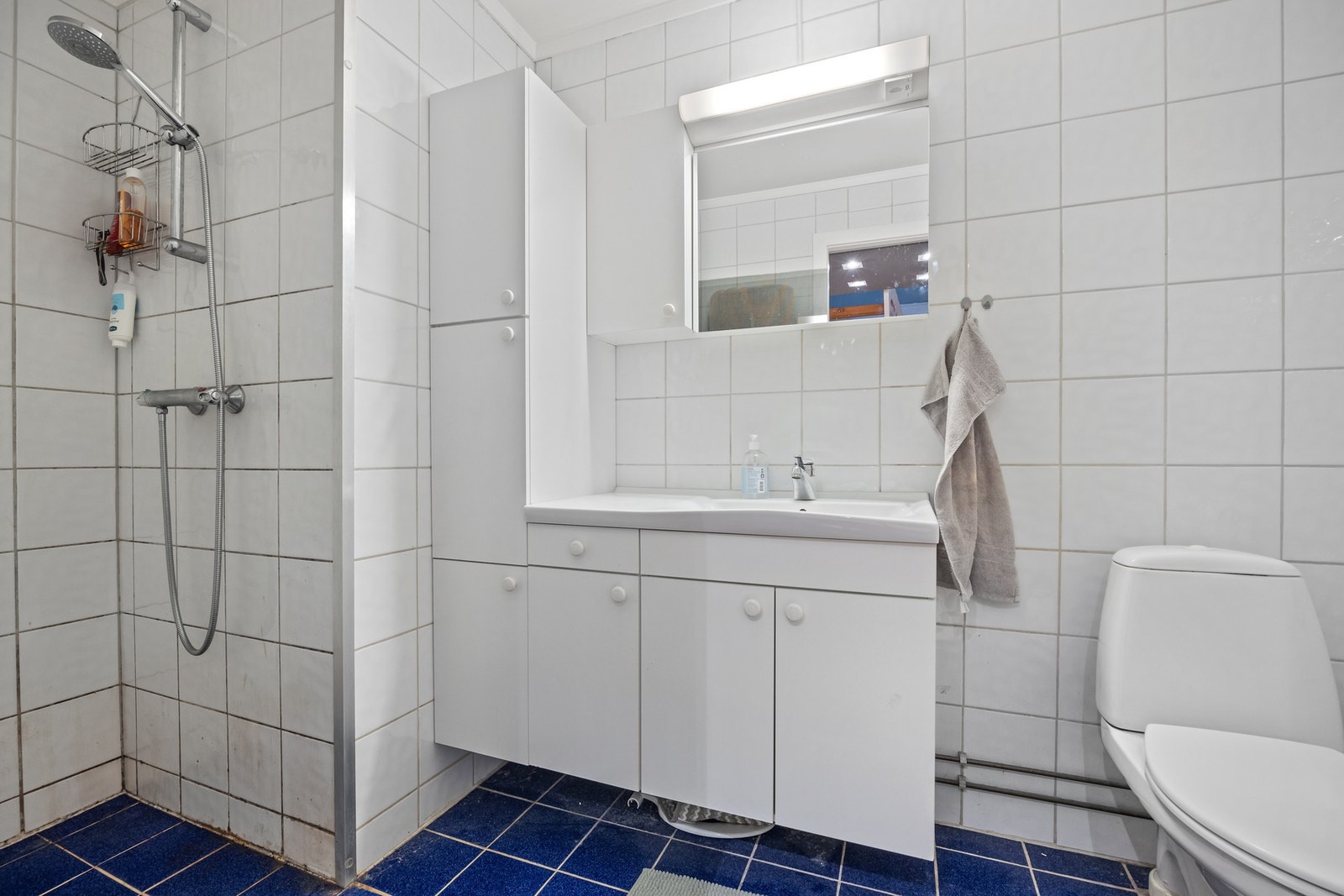 Flislagt baderom innredet med dusj, servant med servantskap og klosett. Praktisk separat vaskerom. Galleribilde