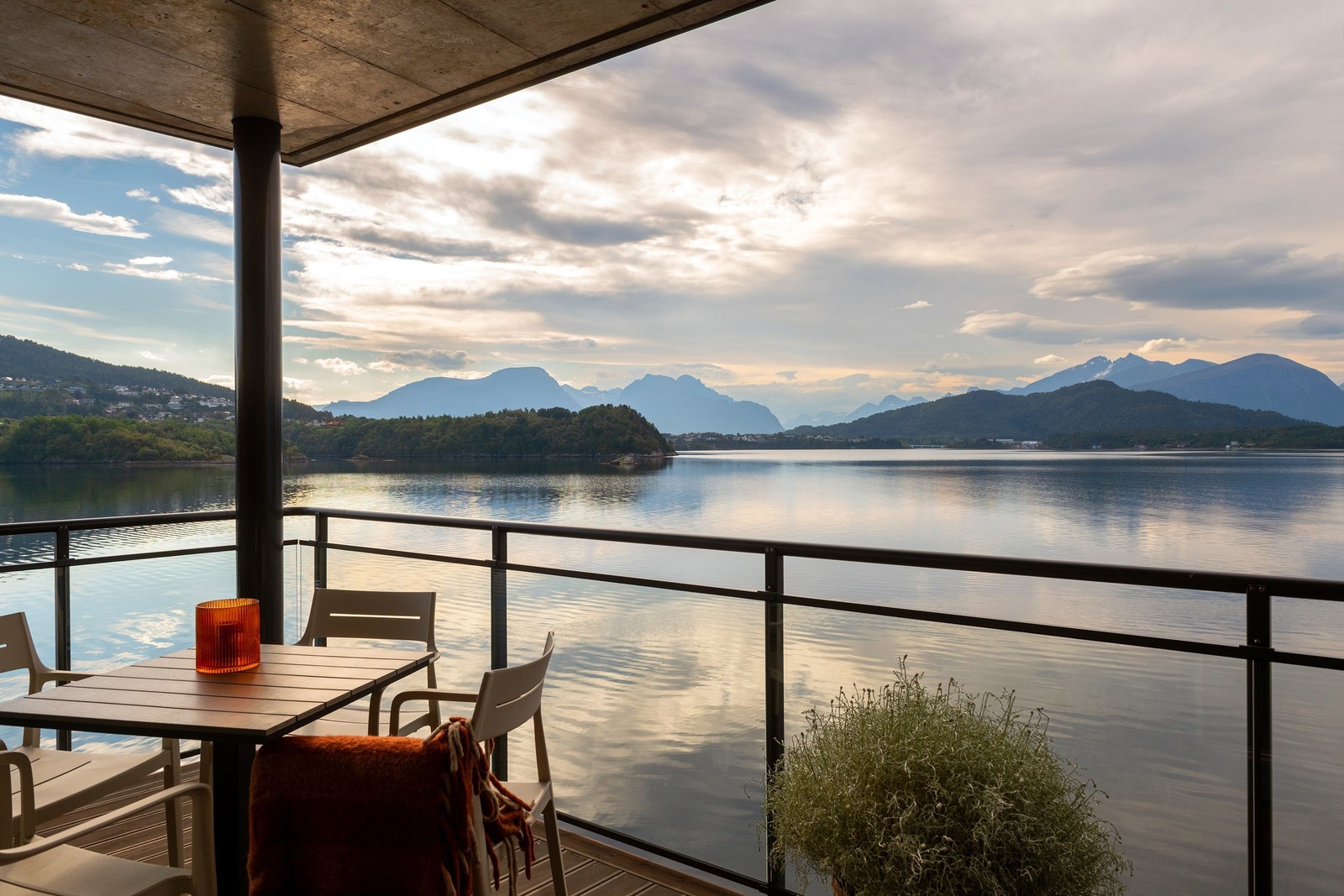 Overbygd terrasse med glassrekkverk med fantastisk utsikt over Borgundfjorden og Sunnmørsalpane - Foto: Stian Wiik Galleribilde