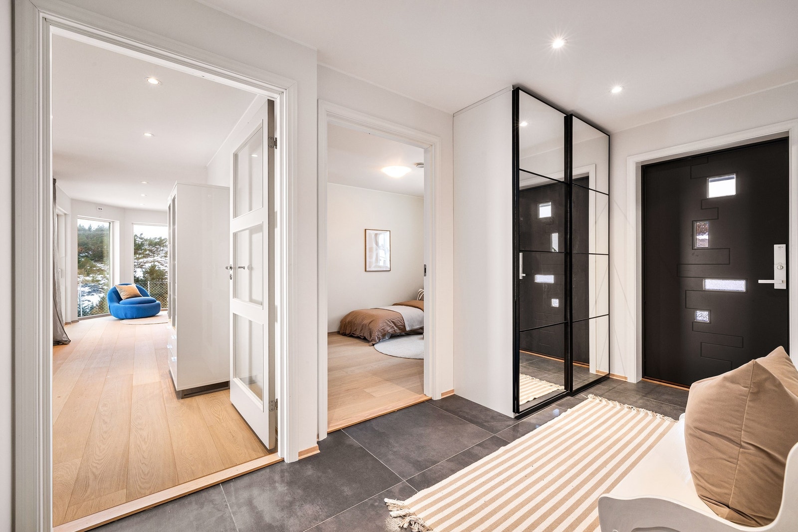 - Romslig entré/gang med skyvedørsgarderobe. Lekker innredning med store, grå fliser og svarte detaljer på garderobe og ytterdør. - Galleribilde