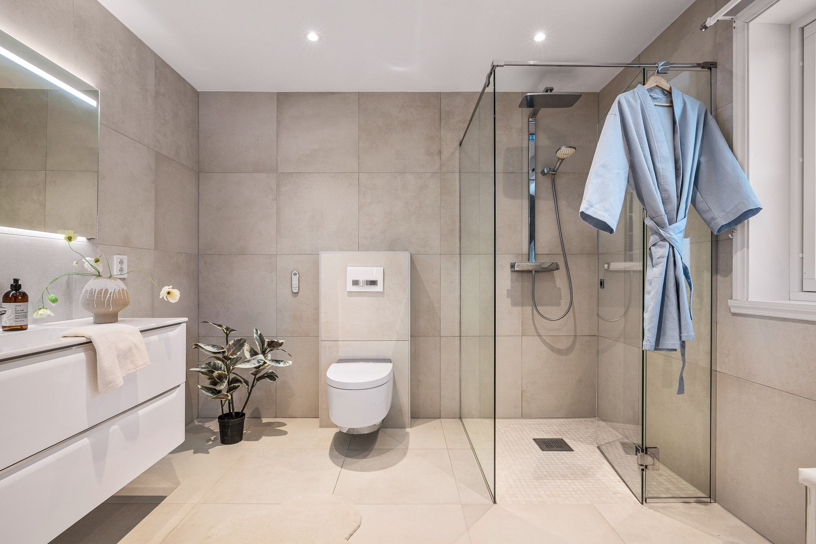 - Store fliser, dusjvegger i glass og dusj med "regn" funksjon, vegghengt wc og stort vindu. Et perfekt bad! - Galleribilde