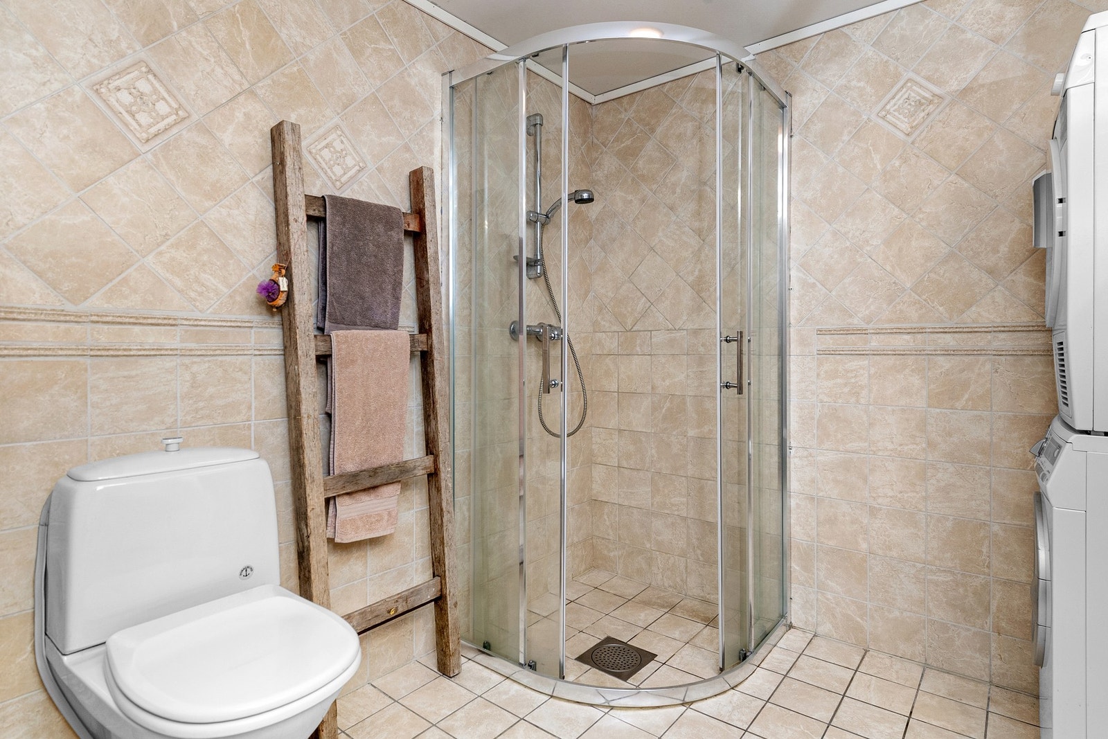 Badet er flislagt med gulvvarme. Det er opplegg for vaskemaskin og tørketrommel. Galleribilde