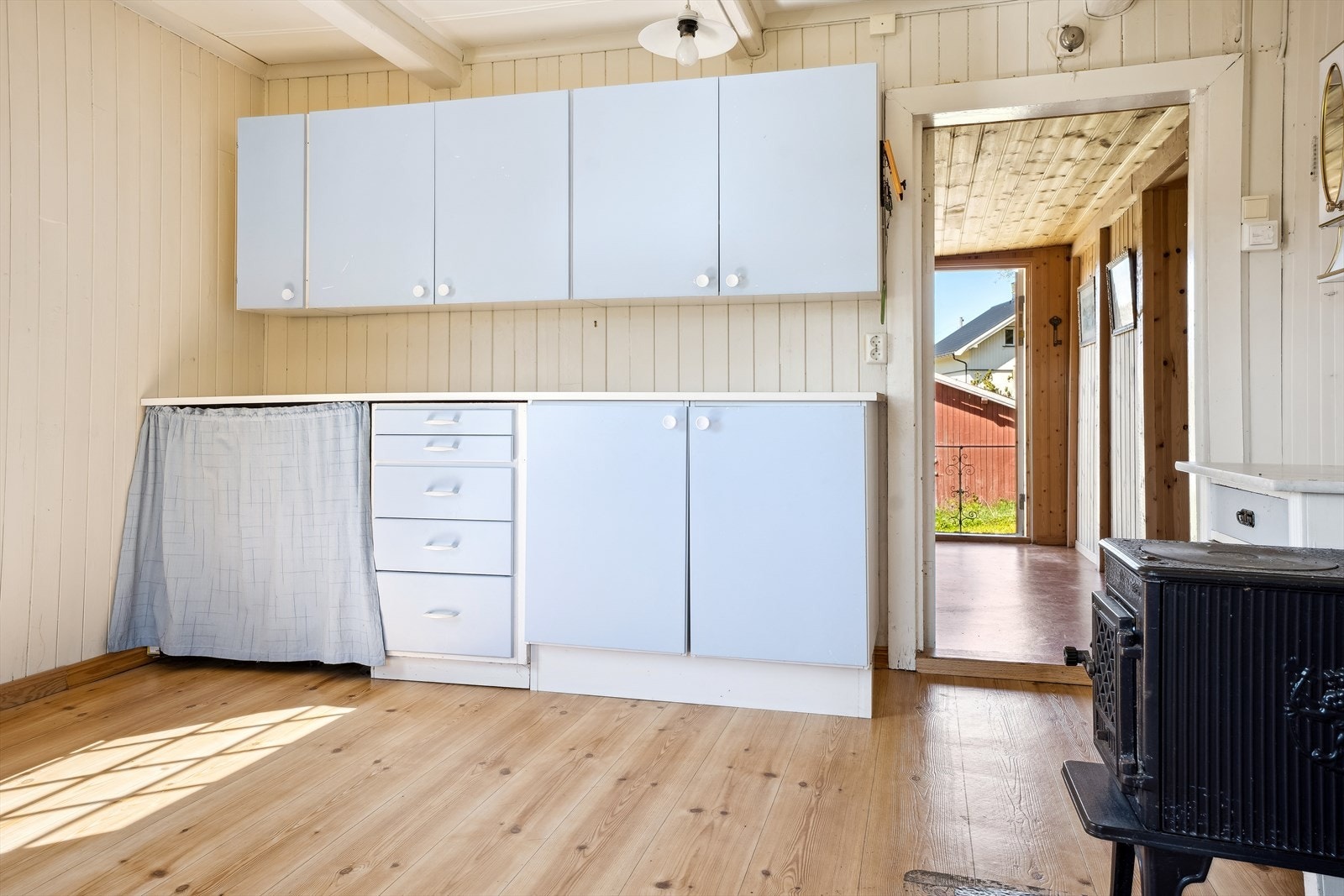 Kjøkkenet har en forenklet innredning med laminerte skrog, glatte fronter og laminert benkeplate med kjøkkenkum Galleribilde