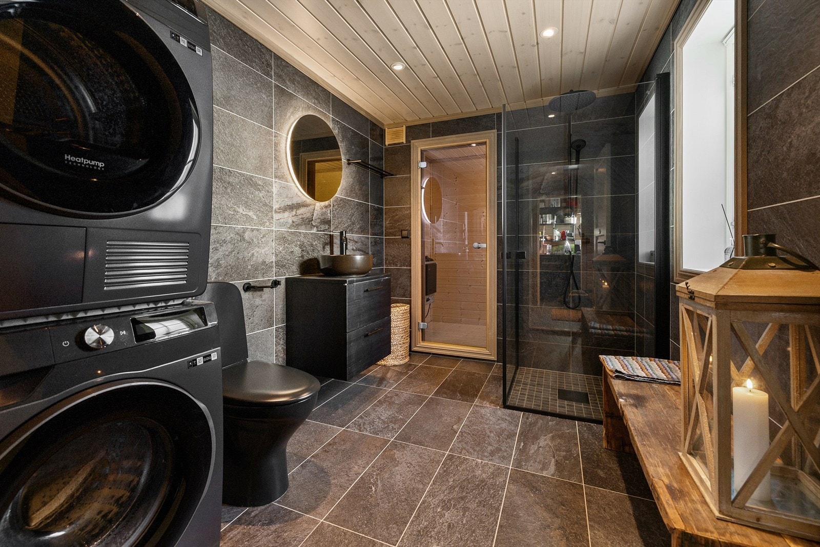 Gulv og vegger har samme mørke skifer fliser og gulvet har elektriske varmekabler. Galleribilde