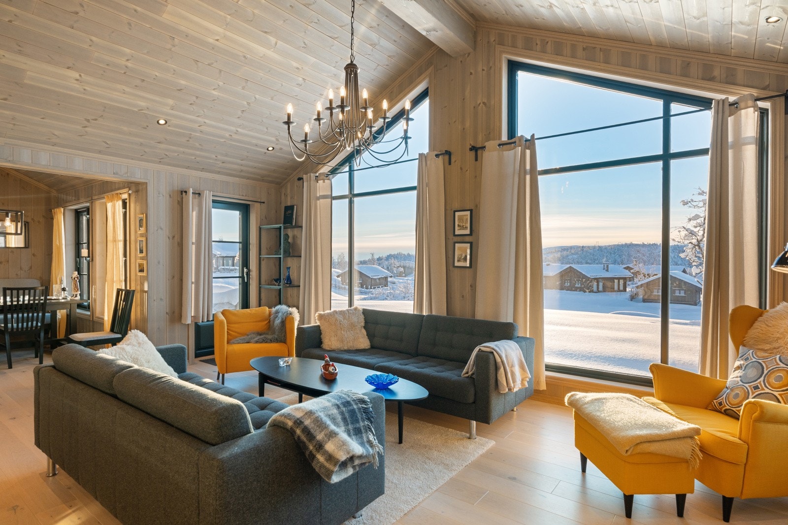 Stuen har god takhøyde og store vindusflater som slipper rikelig med naturlig lys inn og gir flott utsikt mot omkringliggende fjellandskap Galleribilde