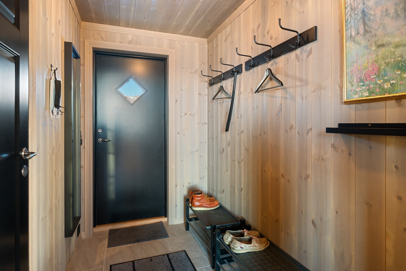 Entréen med flislagt gulv og varmekabler. Her er det gode opphengsmuligheter for yttertøy og sko Galleribilde