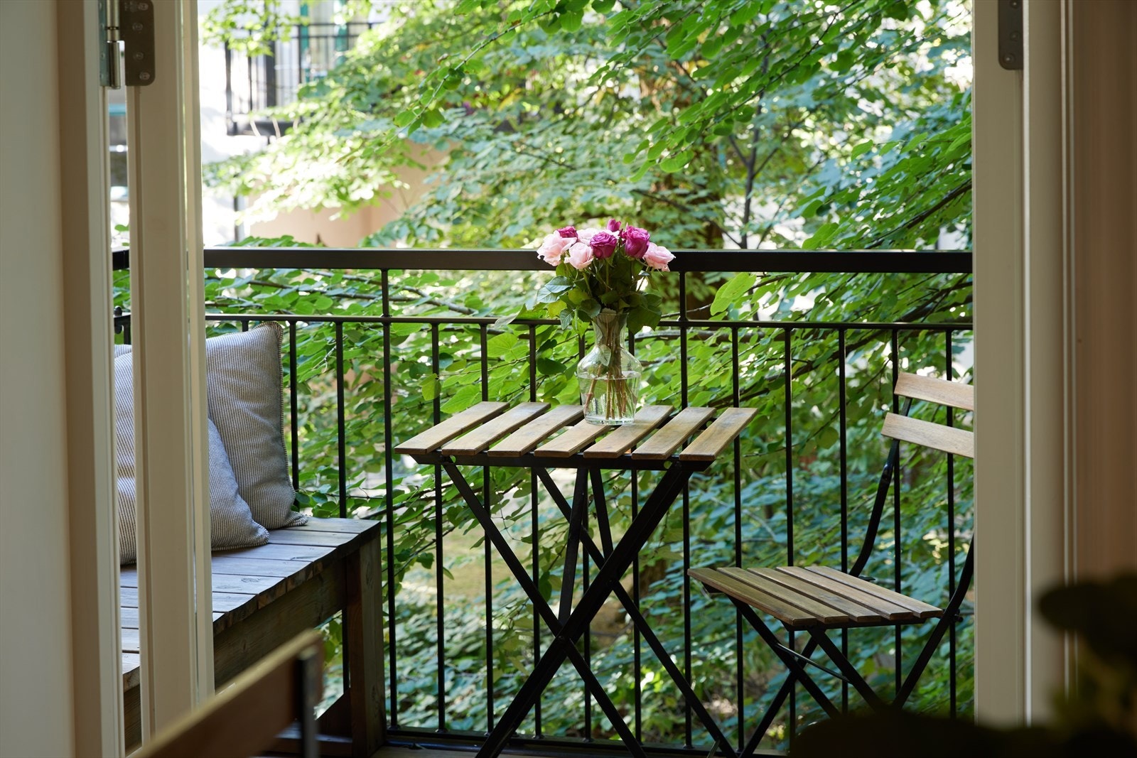Balkongen er skjermet av grønne trær, som skaper en privat og lun uteplass. (Selgers private bilde) Galleribilde