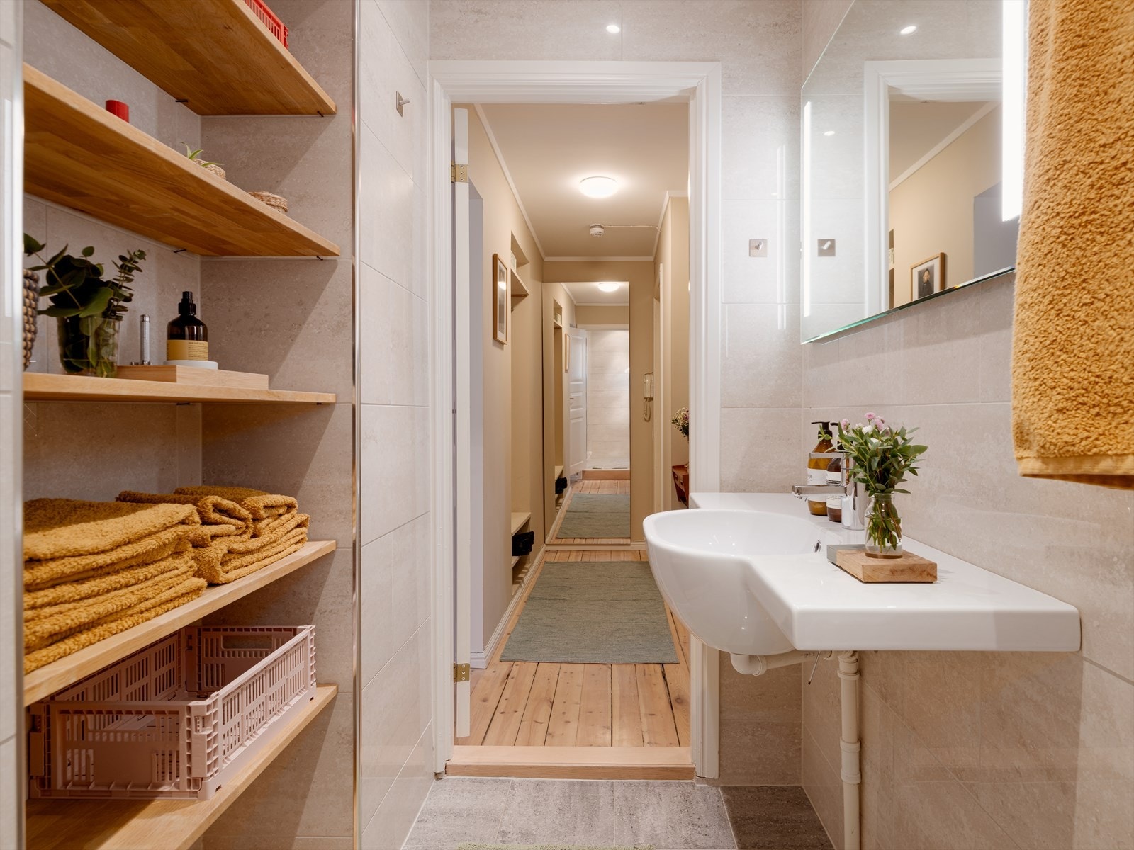 Praktiske hyller i tre gir god oppbevaringsplass for håndklær og toalettsaker. Galleribilde