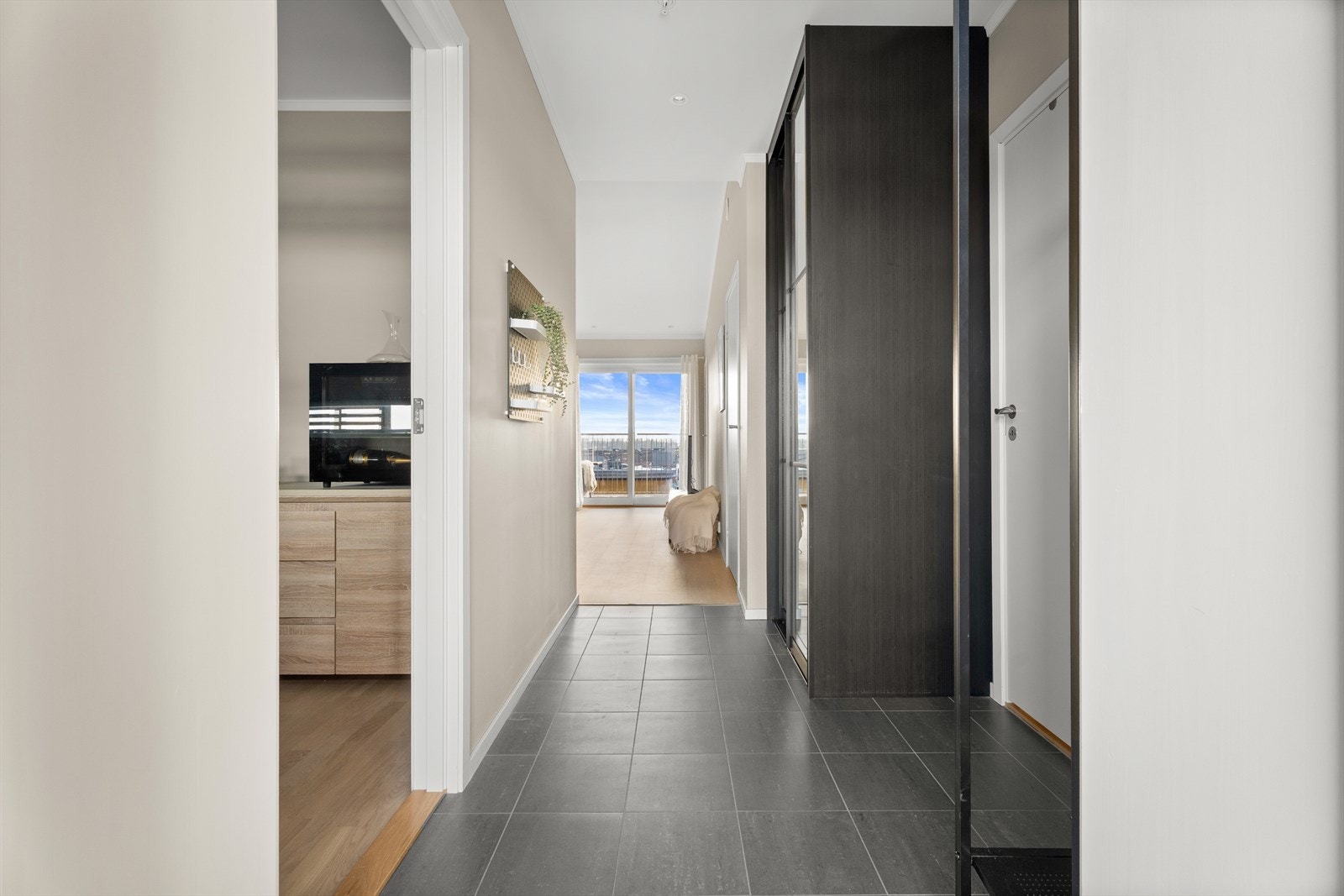 Gangen har slitesterke fliser på gulvet og leder deg videre inn i leilighetens oppholdsrom. Galleribilde