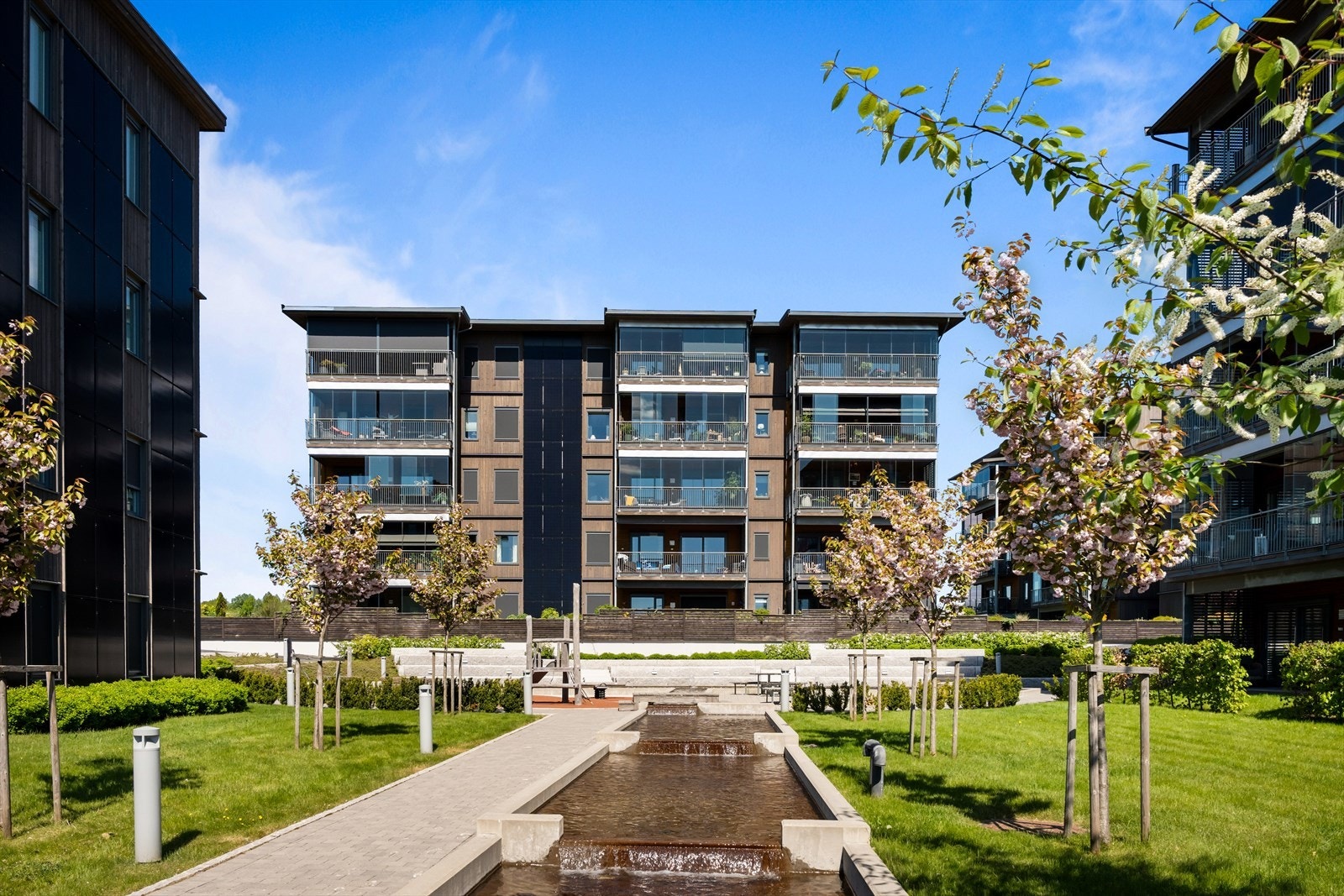 Borettslagets felles tomt er opparbeidet med bekk, hekker, trær og beplantning. Galleribilde