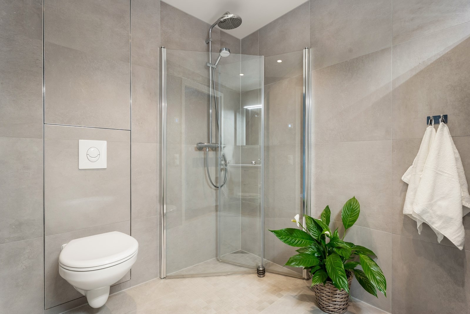 Her er det vegghengt toalett og et praktisk dusjhjørne med innfellbare glassdører. Galleribilde