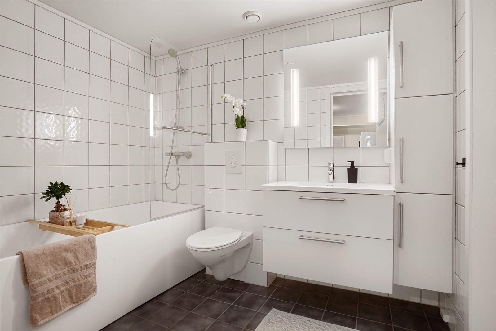 Helfliset bad i underetasje med elektriske varmekabler - vegghengt innredning, toalett, samt smart badekar med dusjløsning Galleribilde