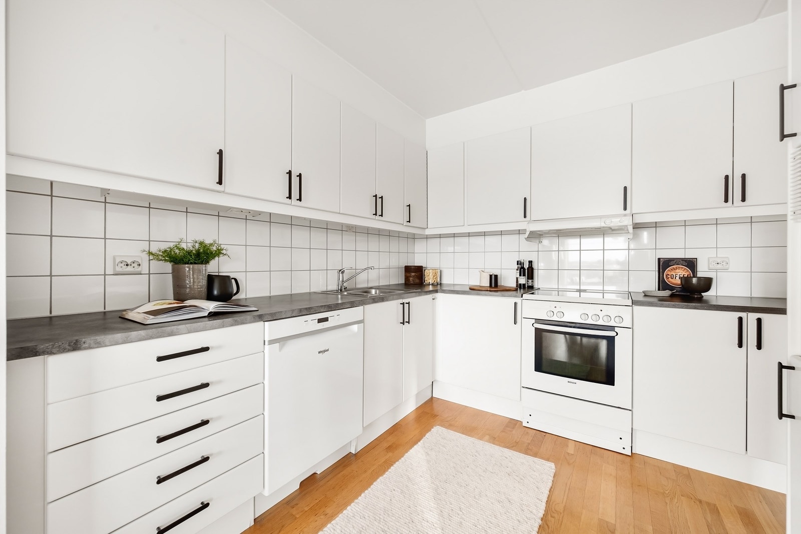 Kjøkkenet har en delvis åpen løsning mot stuen, med slette fronter og laminat benkeplater. Galleribilde