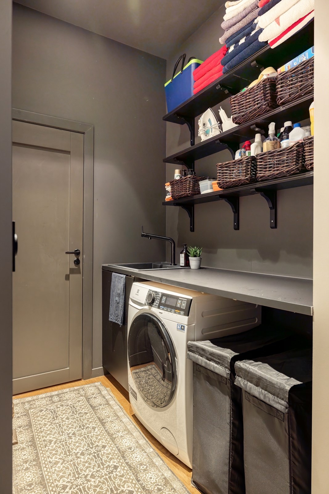 Leiligheten har eget vaskerom utstyrt med arbeidsbenk, hyllesystem, utslagsvask og vaskemaskin. Galleribilde