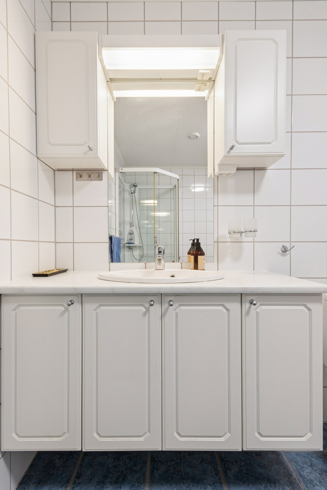 Lys baderomsinnredning med mye oppbevaringsplass for baderomsartikler. Galleribilde