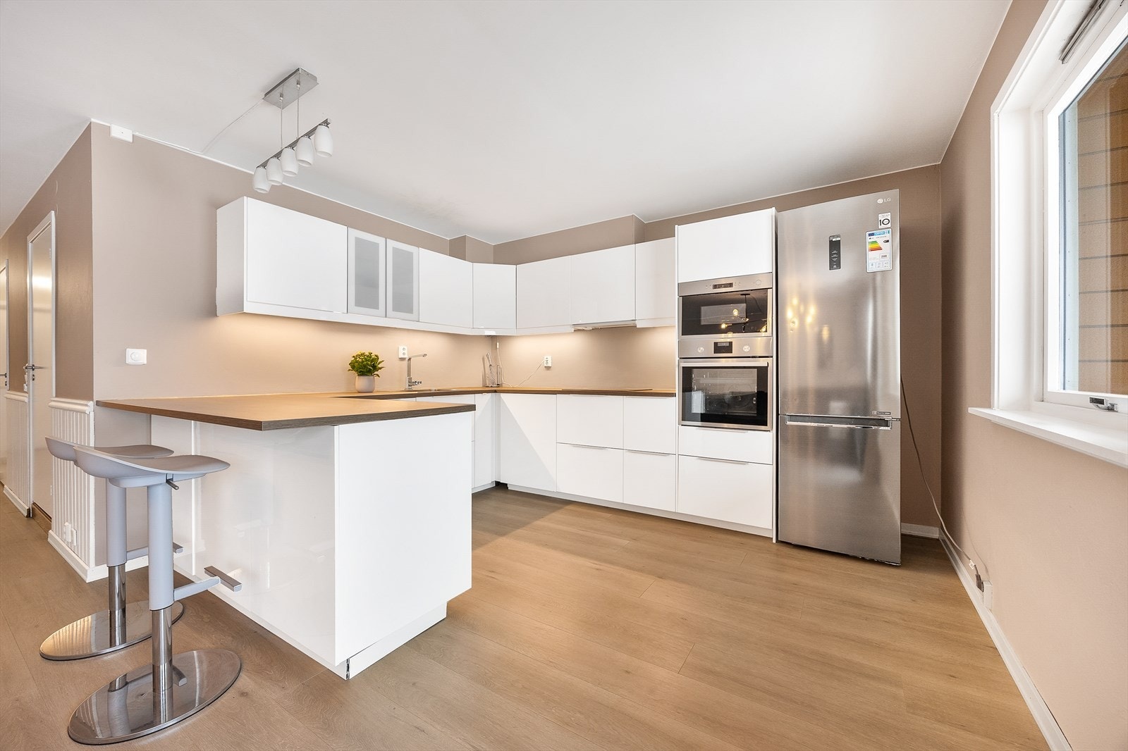 Kjøkkeninnredningen fra IKEA har glatte fronter og en slitesterk laminatbenkeplate. Galleribilde