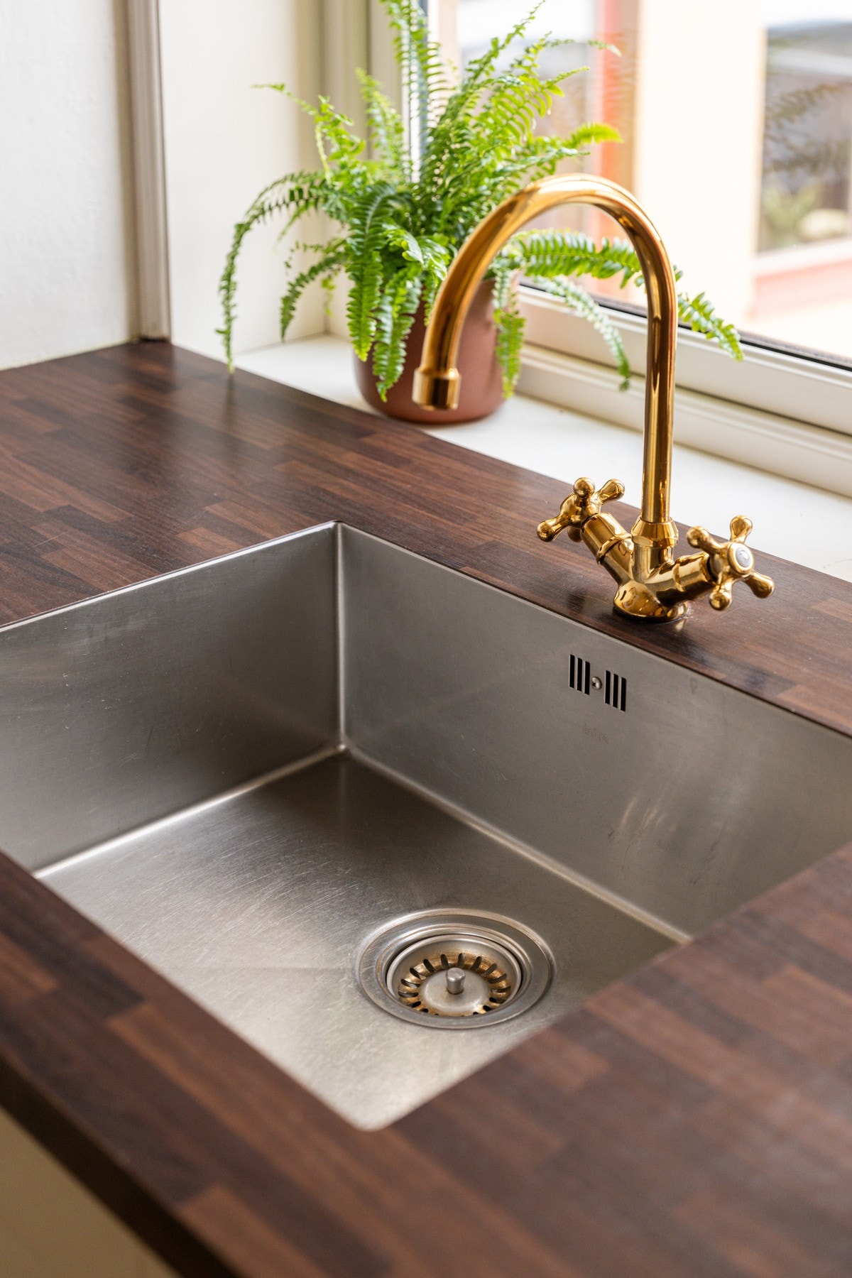 Eksklusiv detalj med ettgreps blandebatteri i messingfinish som tilfører kjøkkenet et sofistikert preg. Galleribilde