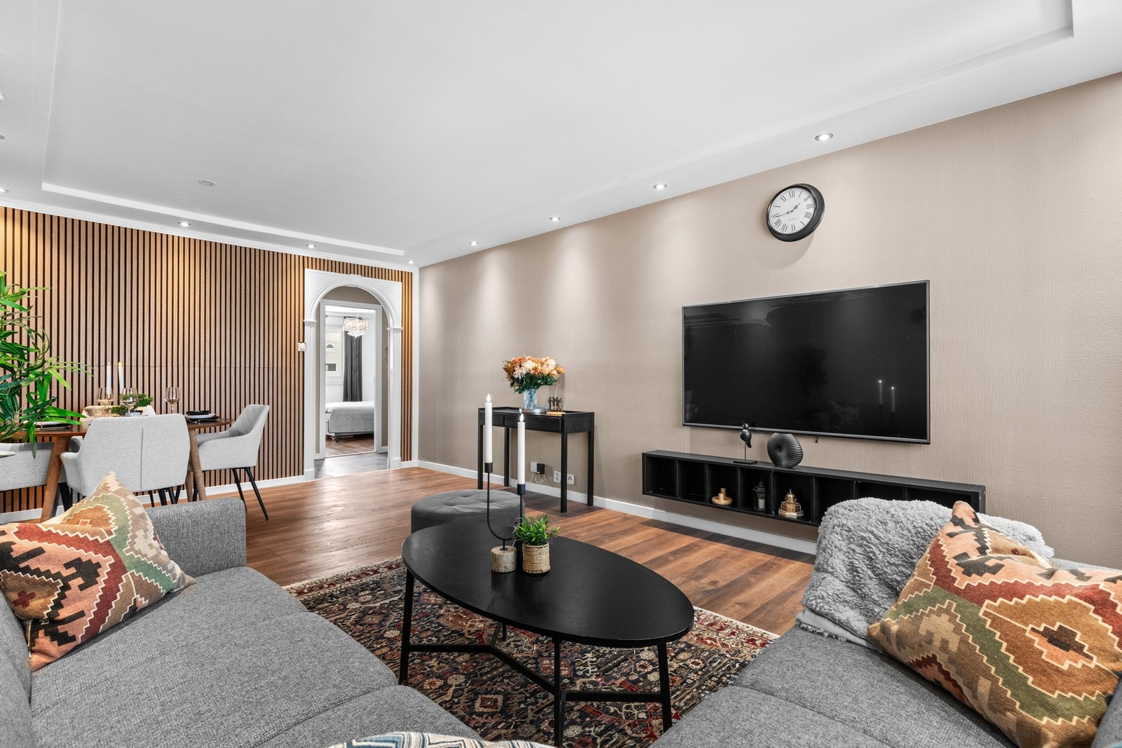 Stuen har en behagelig atmosfære med nedfelte downlights, tidsriktige fargetoner og god veggplass for møblering. TV-løsningen er stilrent integrert og gir et ryddig uttrykk. Galleribilde