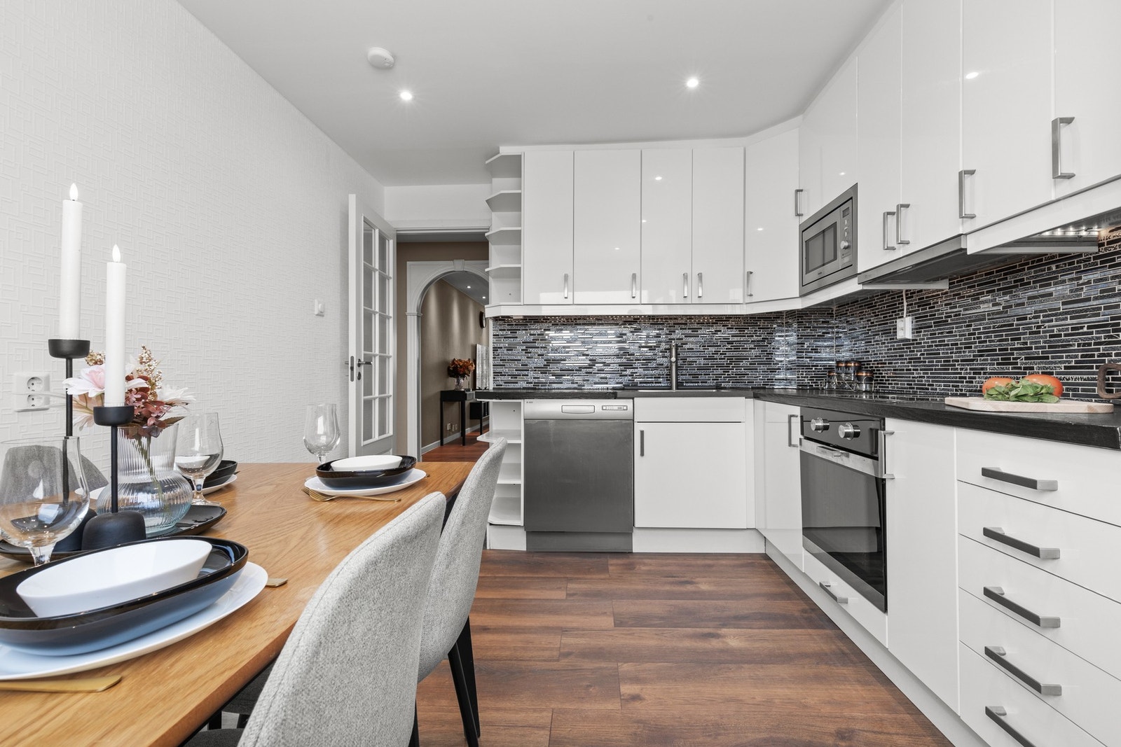 Stilrent kjøkken med god arbeidsflyt og rikelig med skapplass. Flisene over benk gir et lekkert og helhetlig preg. Galleribilde