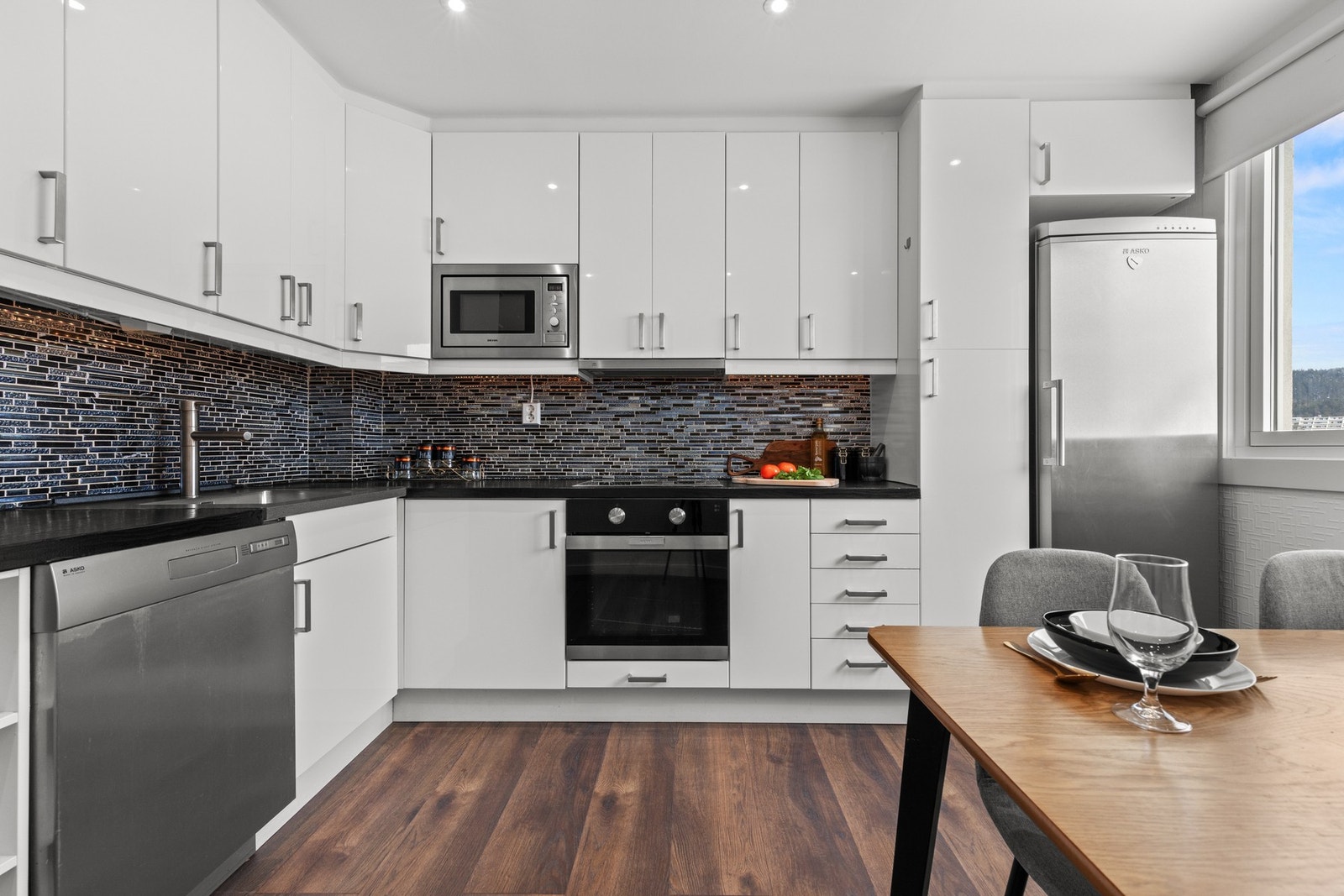 Praktisk og funksjonell kjøkkenløsning med smarte oppbevaringsmuligheter og gode arbeidsflater - perfekt for både hverdagsmat og hyggelige middager. Galleribilde