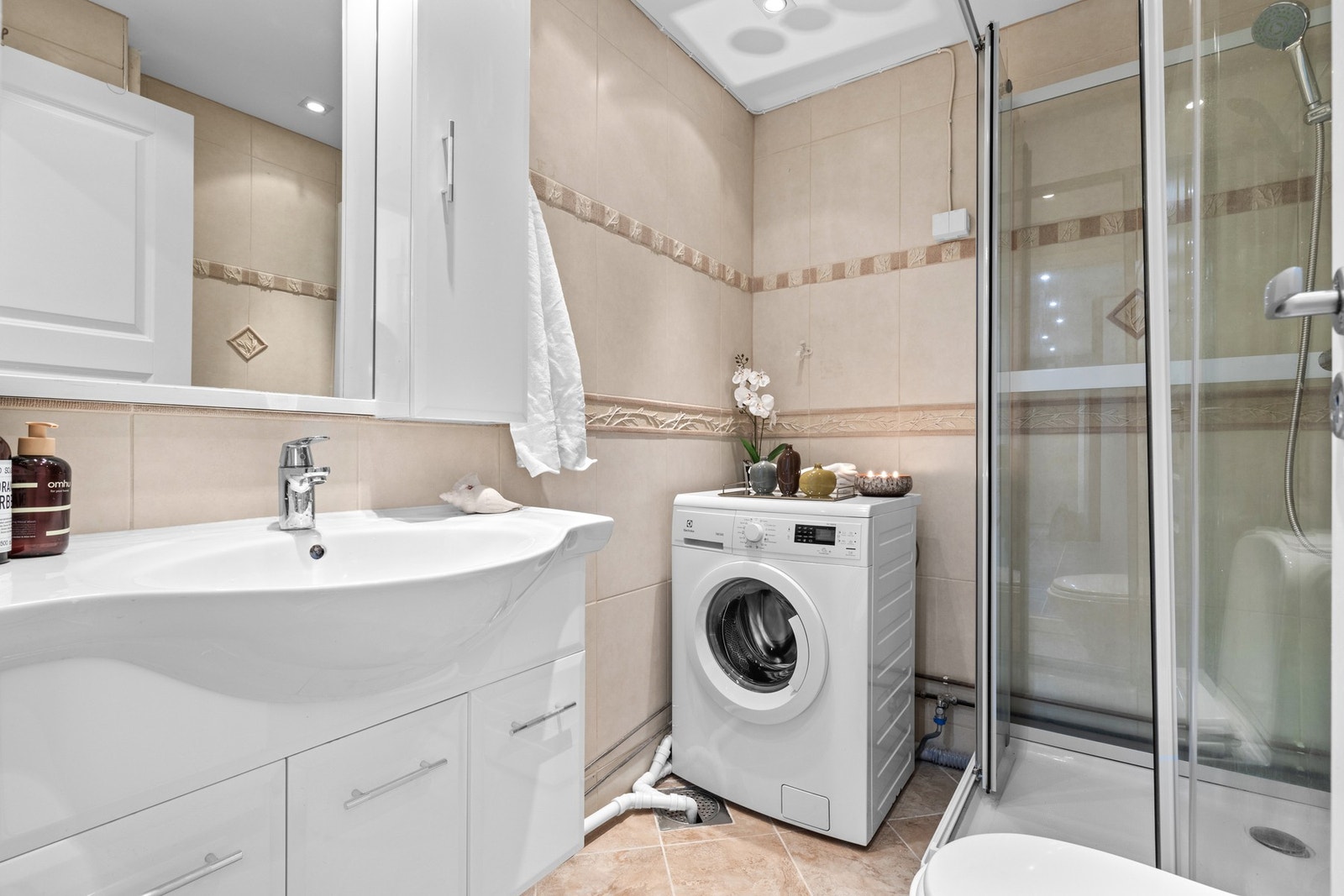 Bad med gode oppbevaringsmuligheter og plass til vaskemaskin. Her får du en praktisk hverdag samlet på ett rom. Galleribilde