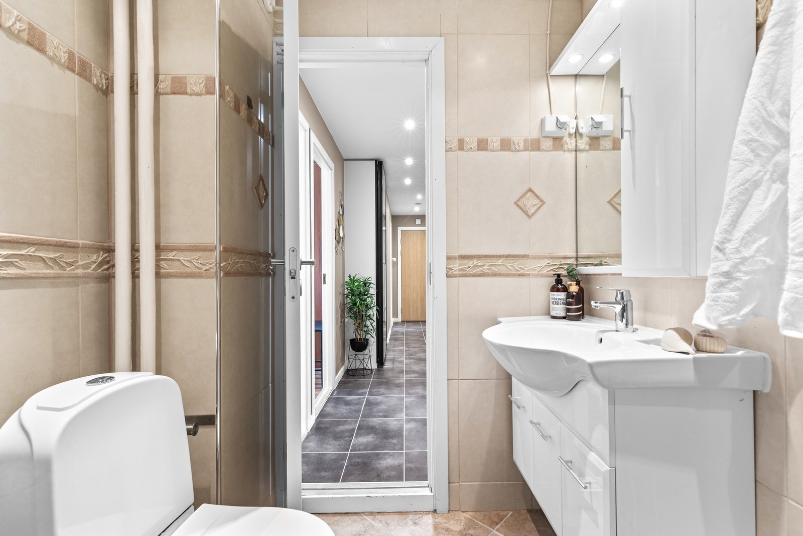 Flislagt baderom med dusjløsning og mekanisk avtrekk. Rommet er effektivt innredet og utnytter plassen godt. Galleribilde