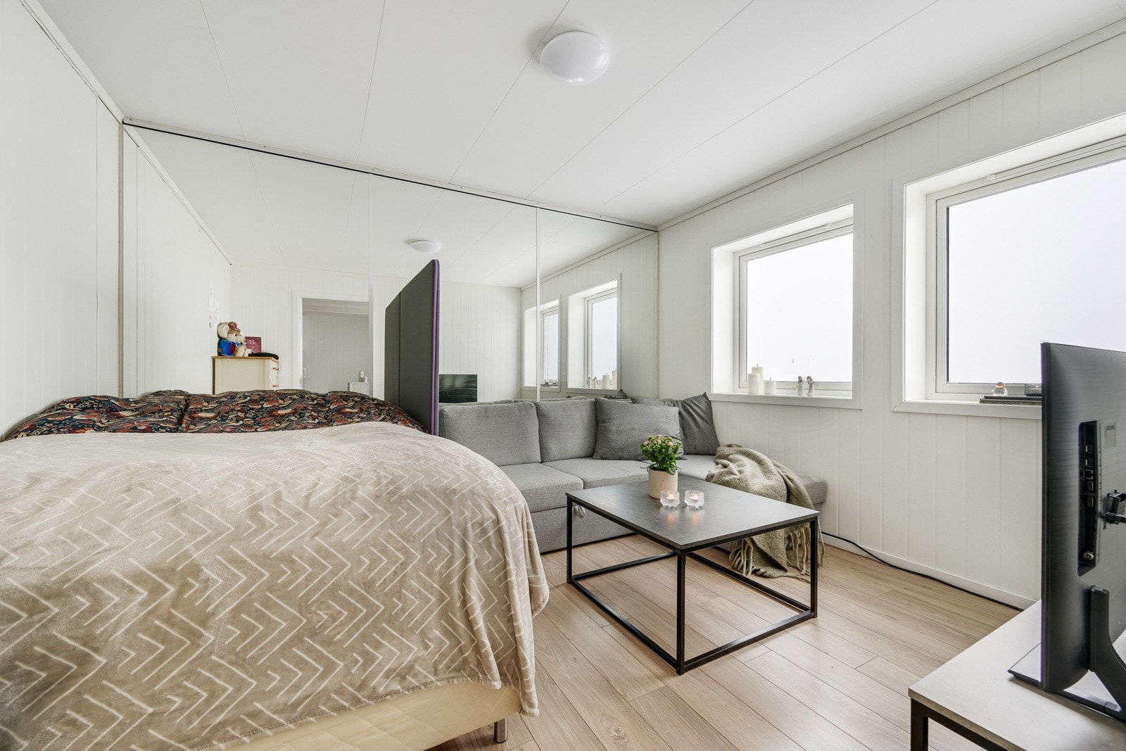 På innsiden av kjøkkenet er stuen som også brukes til soverom Galleribilde