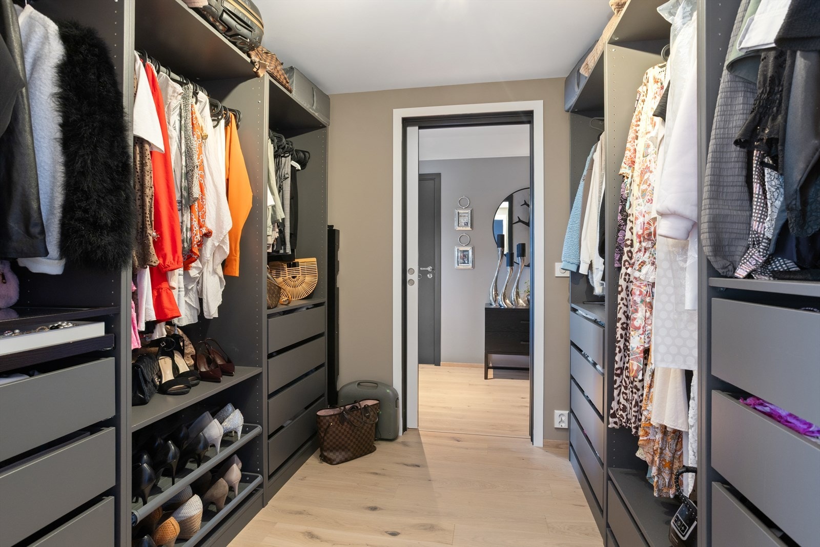 Man kommer inn i hovedrommet via en stor og imponernde walk-in garderobe med skyvedører i hver ende. Galleribilde