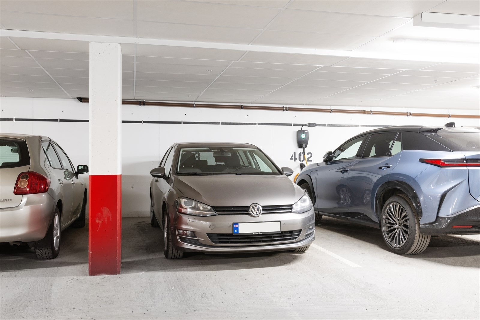 Leiligheten disponerer 1. stk. garasjeplass i byggets P-hus, på nedre etasjeplan. Garasjeplassen er markert "203". Alle parkeringsplassene i garasjeanlegget i underetasjen leveres klargjort for tilkobling til ladestasjon fra utbygger. Galleribilde
