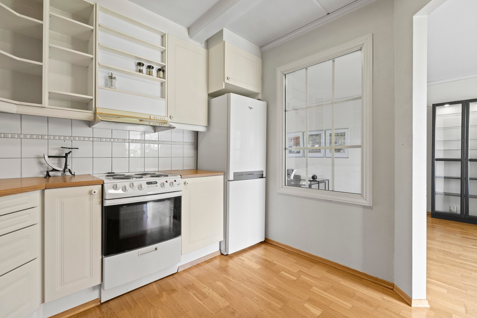 Eldre profilert kjøkkeninnredning trolig fra byggeår, laminat benkeplate, fliser over benk. Galleribilde