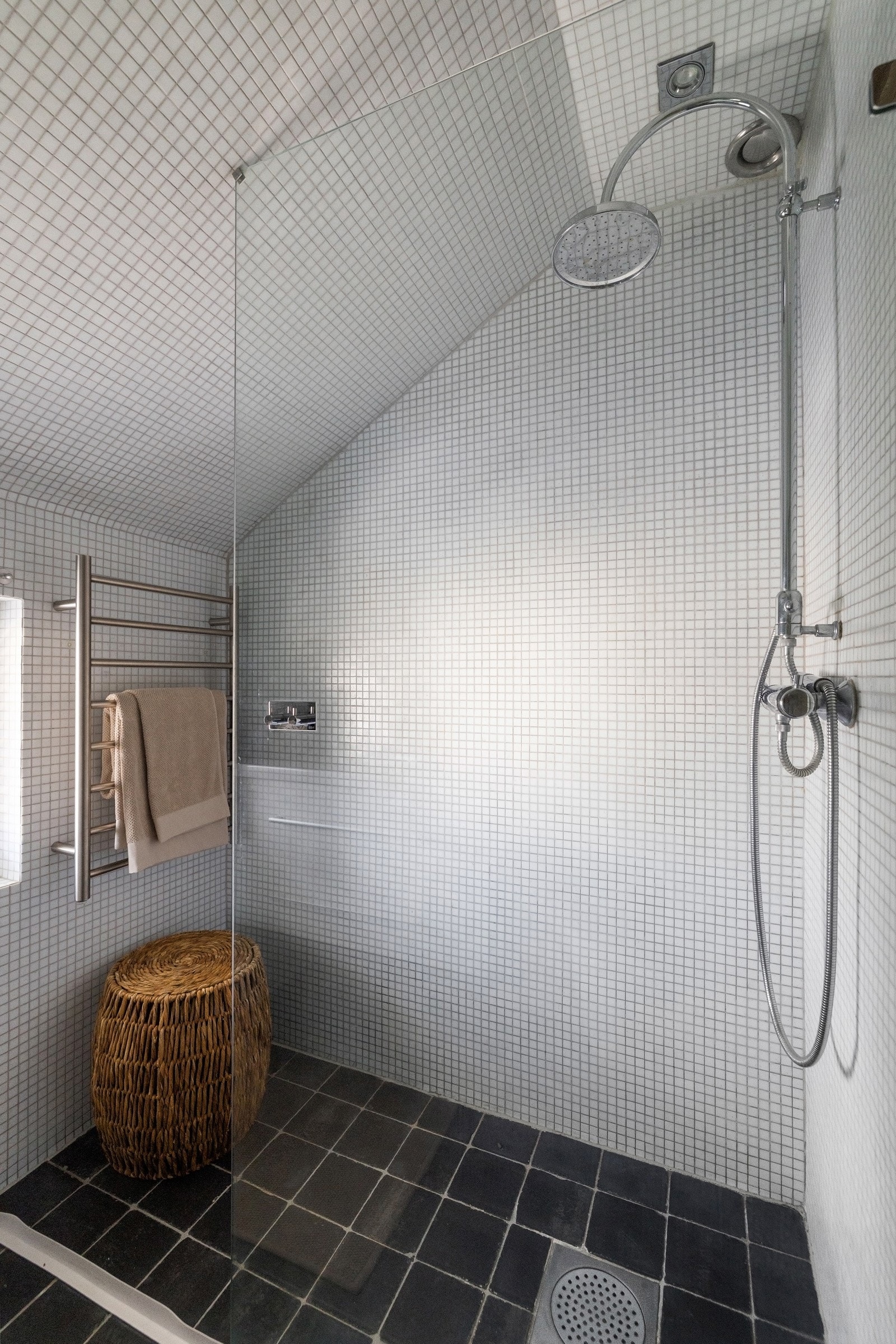 Overflatene består av fliser på gulv med elektriske varmekabler, samt mosaikkfliser på både vegger og i himling, noe som gir rommet et helhetlig og moderne uttrykk. Galleribilde