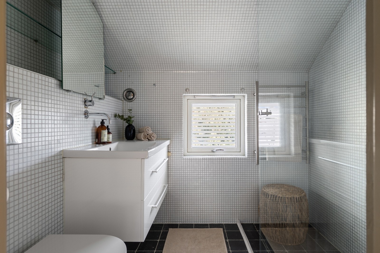 Badet fra 2010 er innredet med dusjnisje med glassvegg, vegghengt toalett og møbel med nedsenket servant og speil. Galleribilde