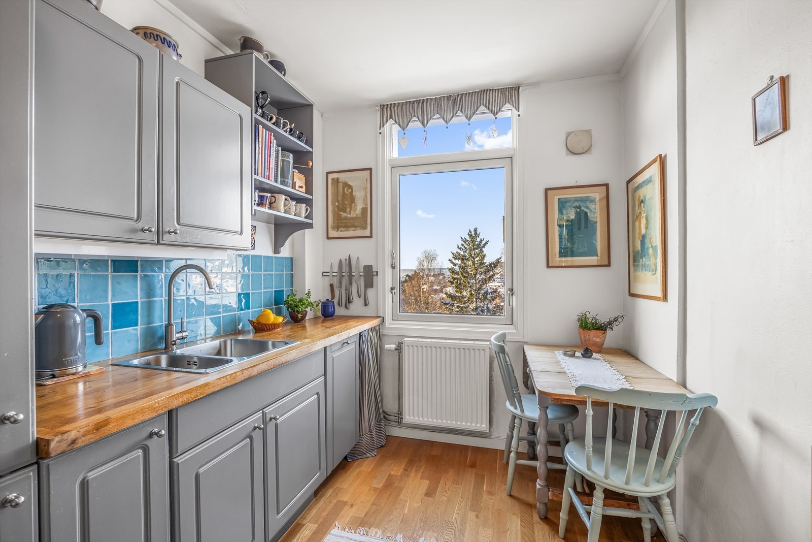 Kjøkkeninnredningen har profilerte, grå fronter og benkeplate i heltre. Galleribilde