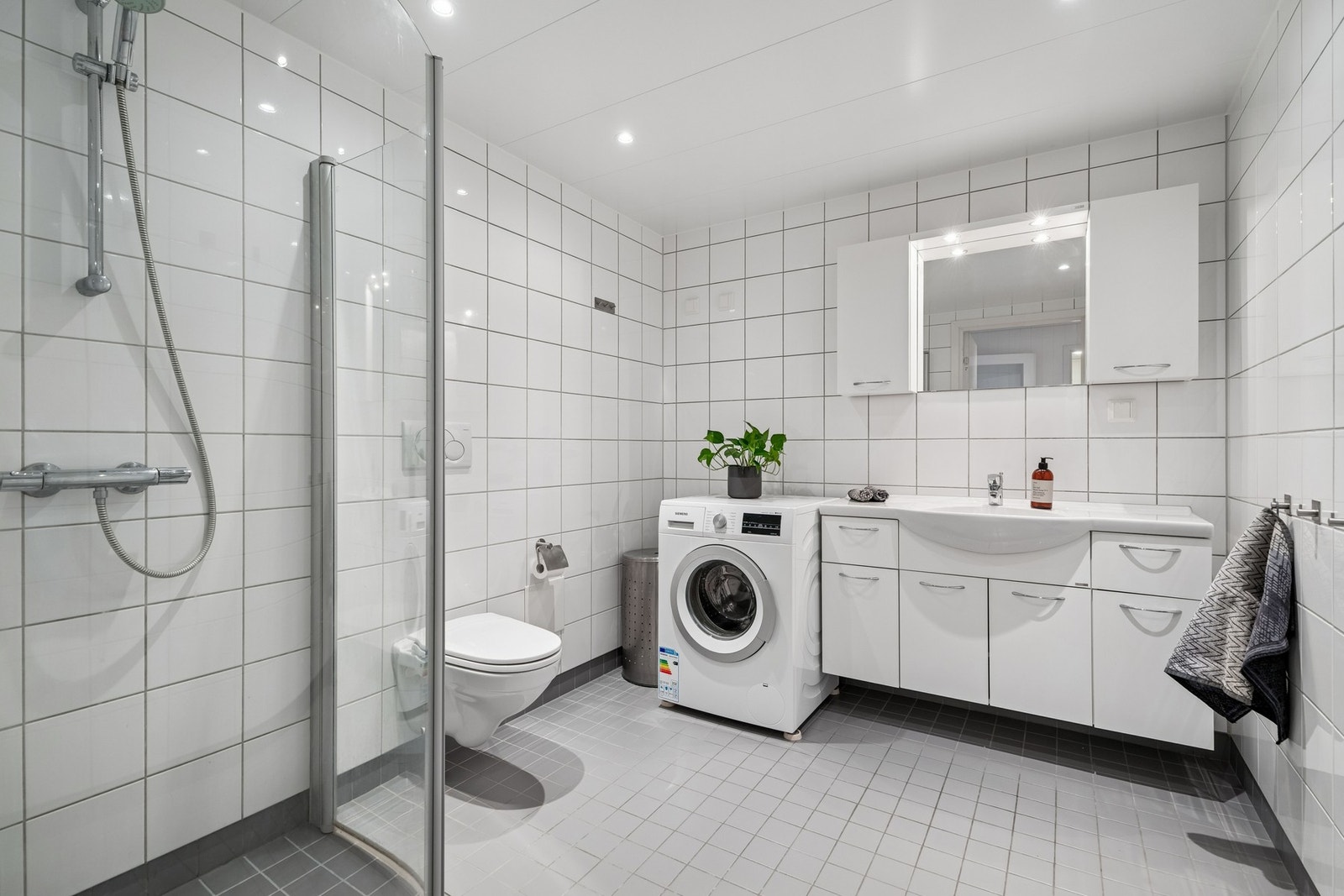 Romslig, flislagt baderom. Galleribilde