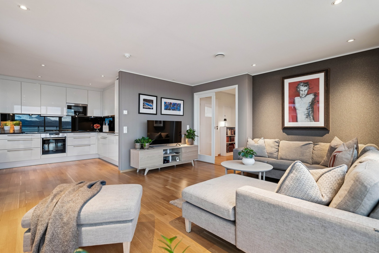 Stuen er i en åpen, sosial løsning mot kjøkkenet. Galleribilde