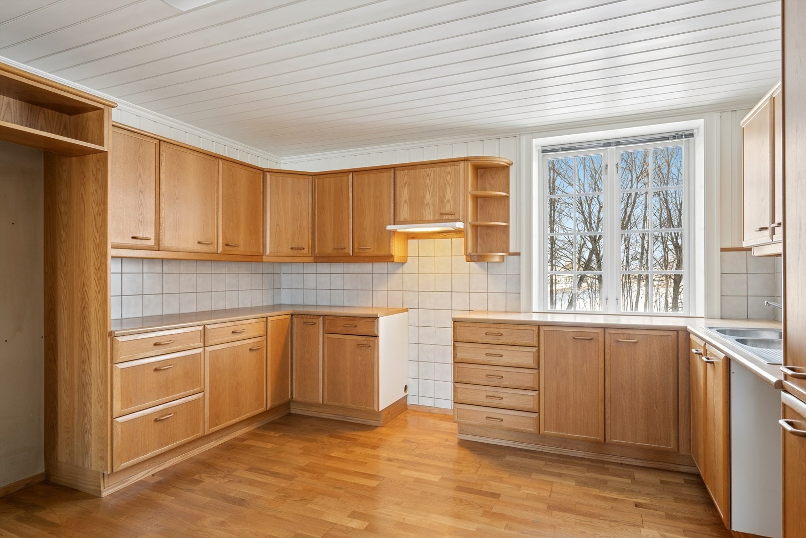 Kjøkkeninnredningen fra 1990 har fyllingsfronter og godt med skapplass i over- og underskap. Galleribilde