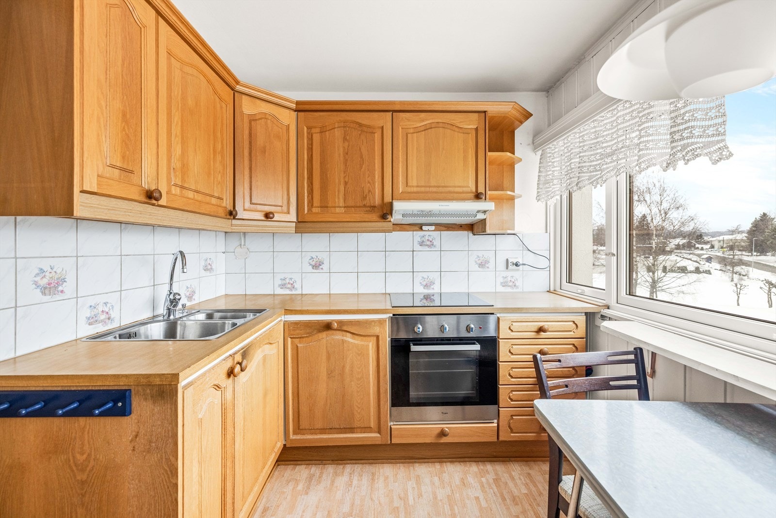 Profilert innredning med laminat benkeplate og fliser mellom benk og overskap. Galleribilde